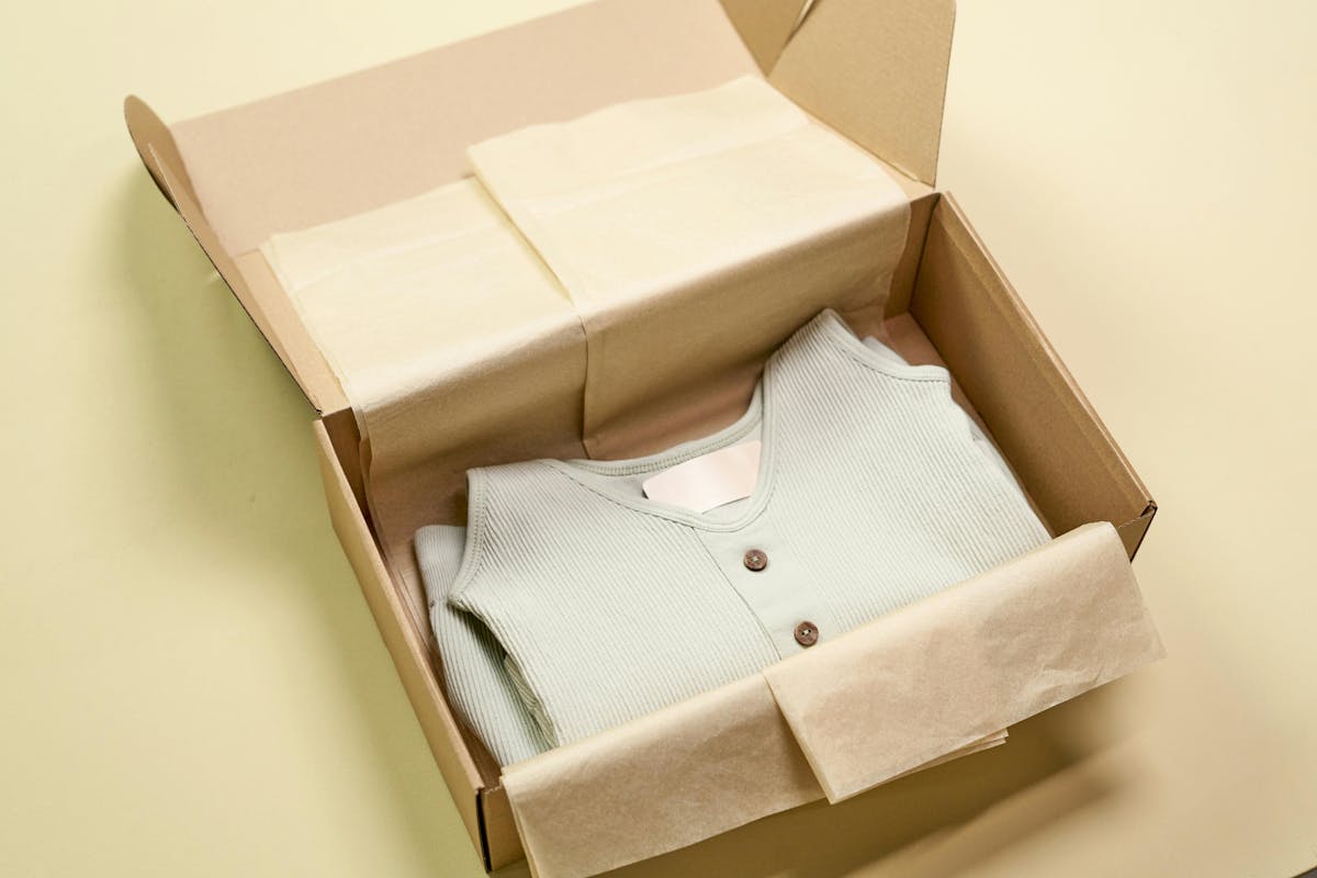 Sustainable cardboard box with a neatly folded shirt with clothing label Sustainable cardboard box with a neatly folded shirt with clothing label