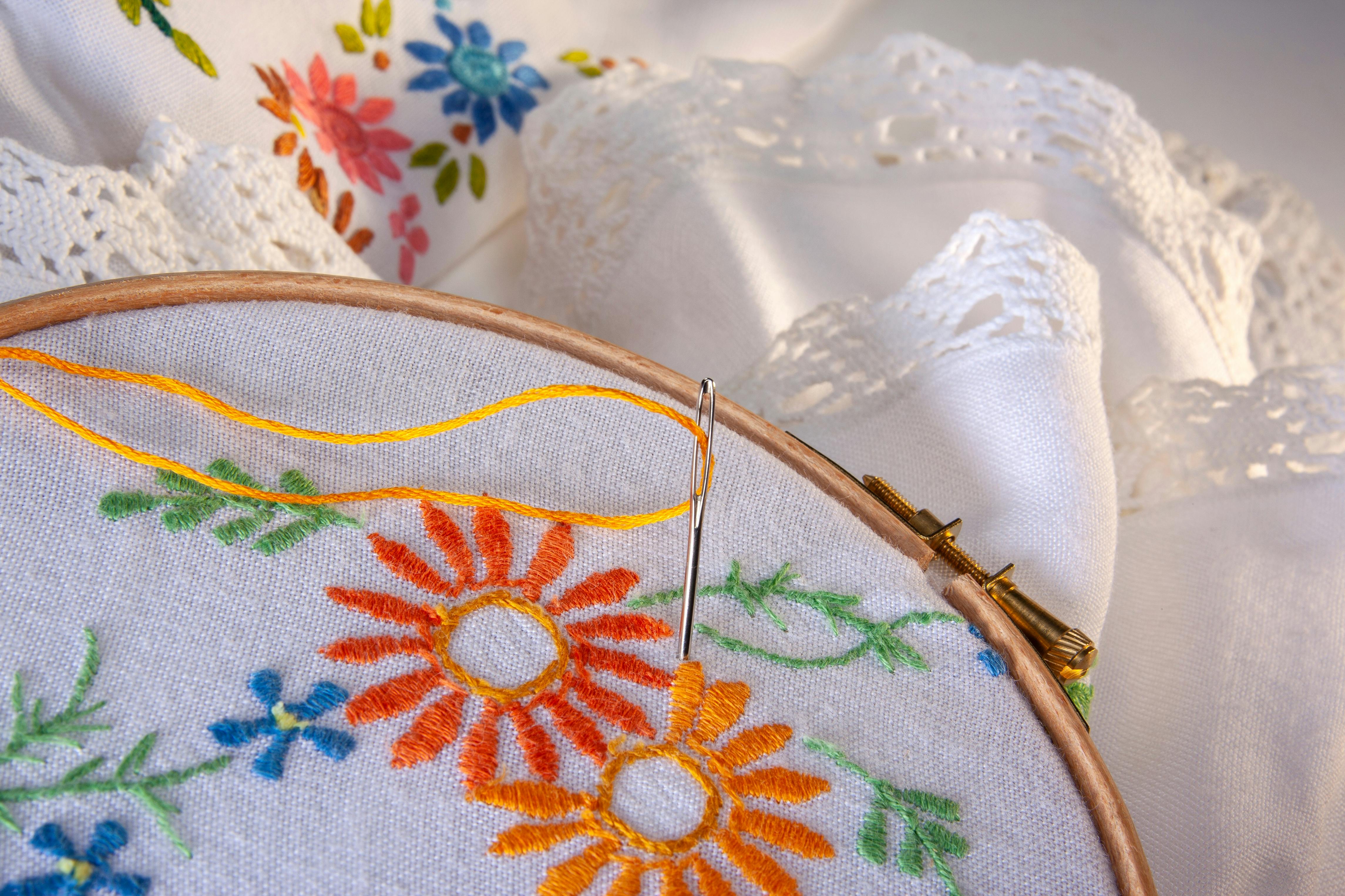  embroidery hoop with half finished embroidered flowers on lace