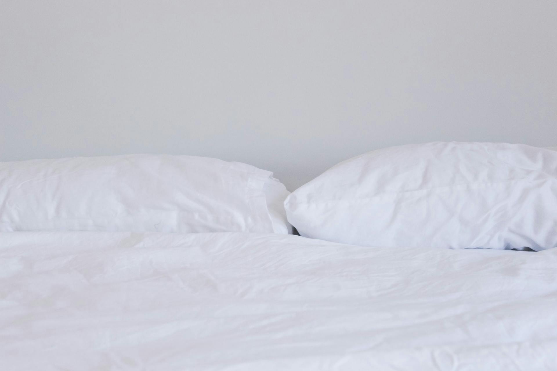  Un lit avec des oreillers et des draps blancs bien propres