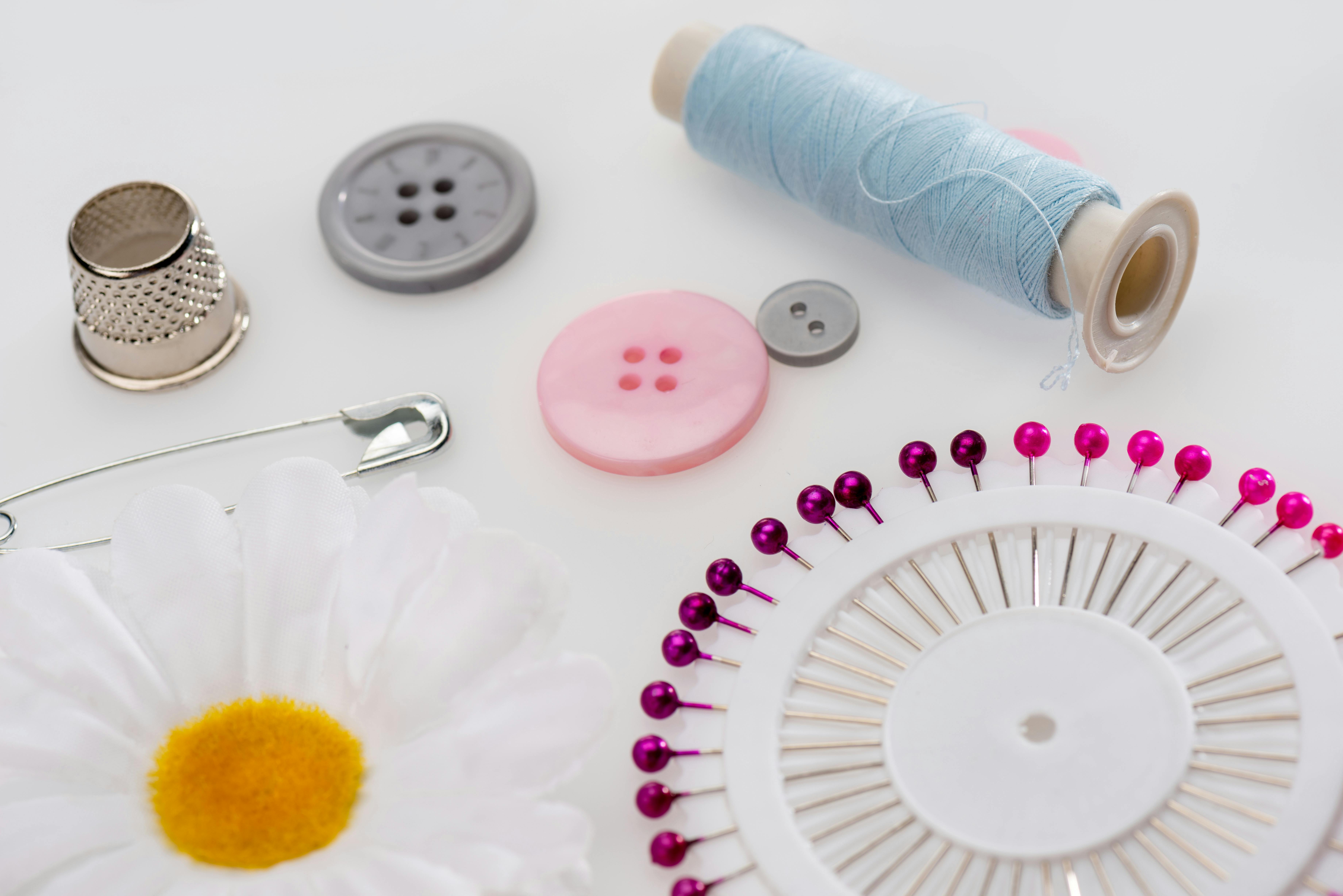  close up photo of sewing notions like pins, buttons and thread