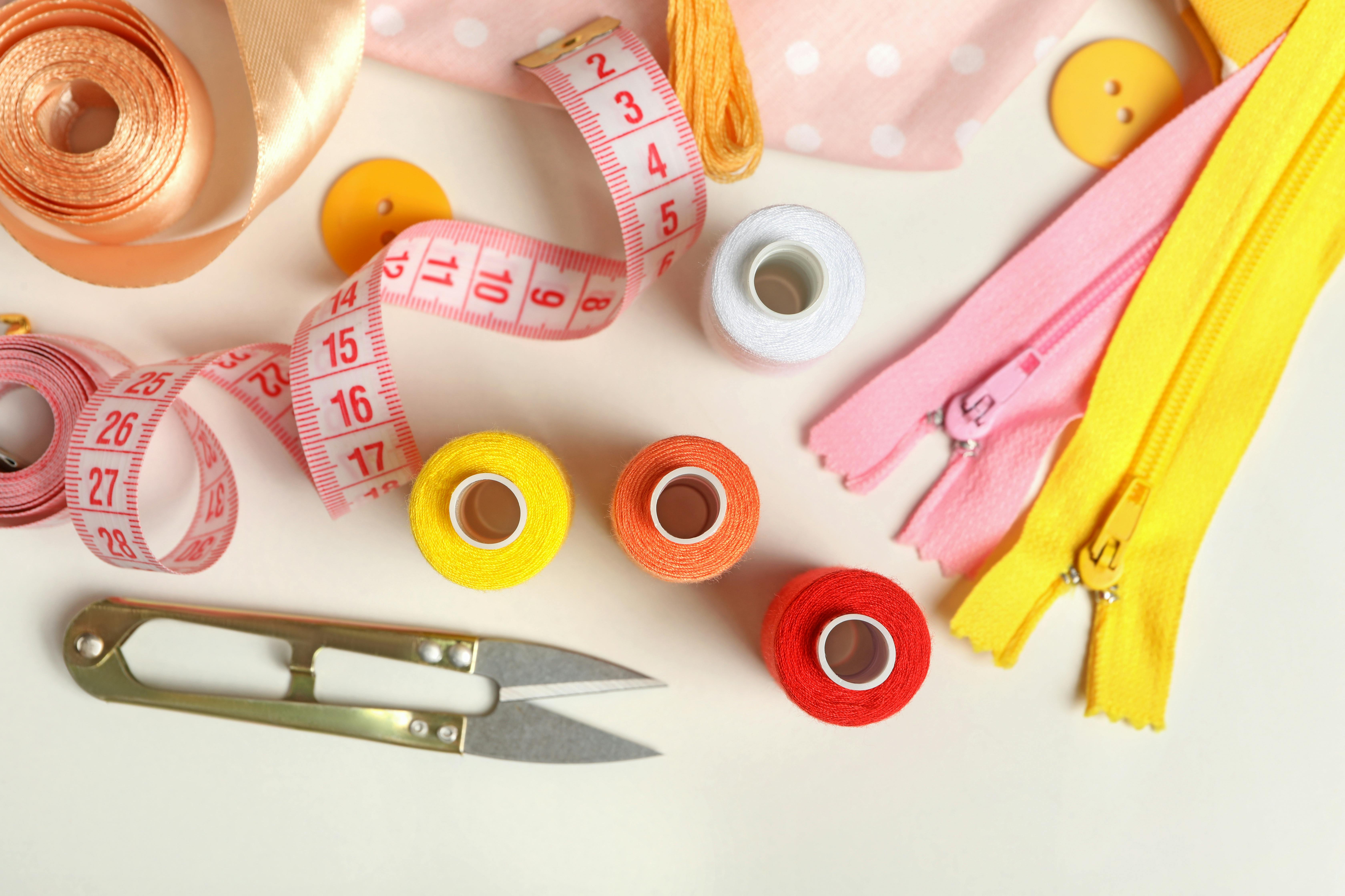  flat lay of sewing supplies like thread, snips, measuring tape