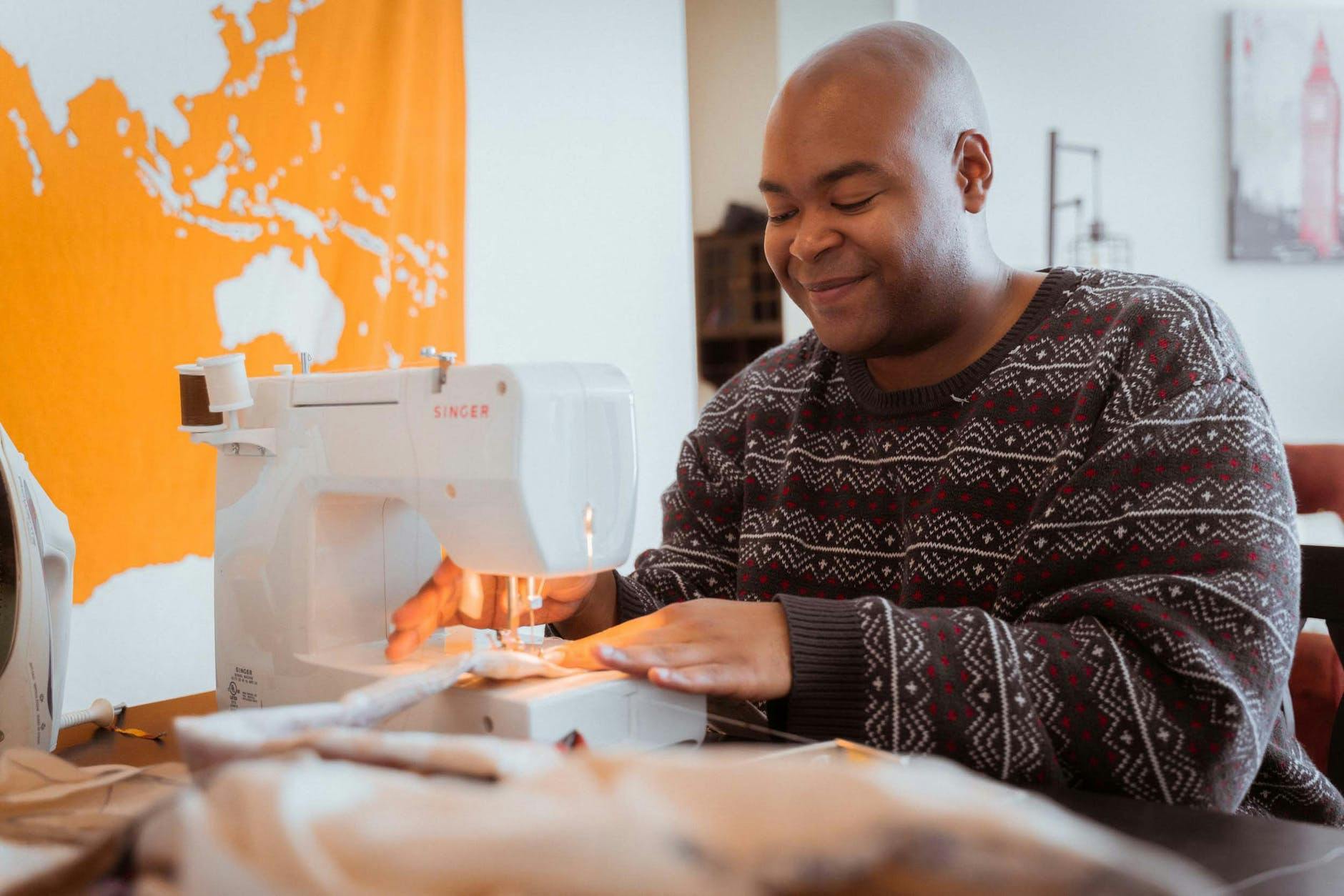  un hombre cose con una sonrisa