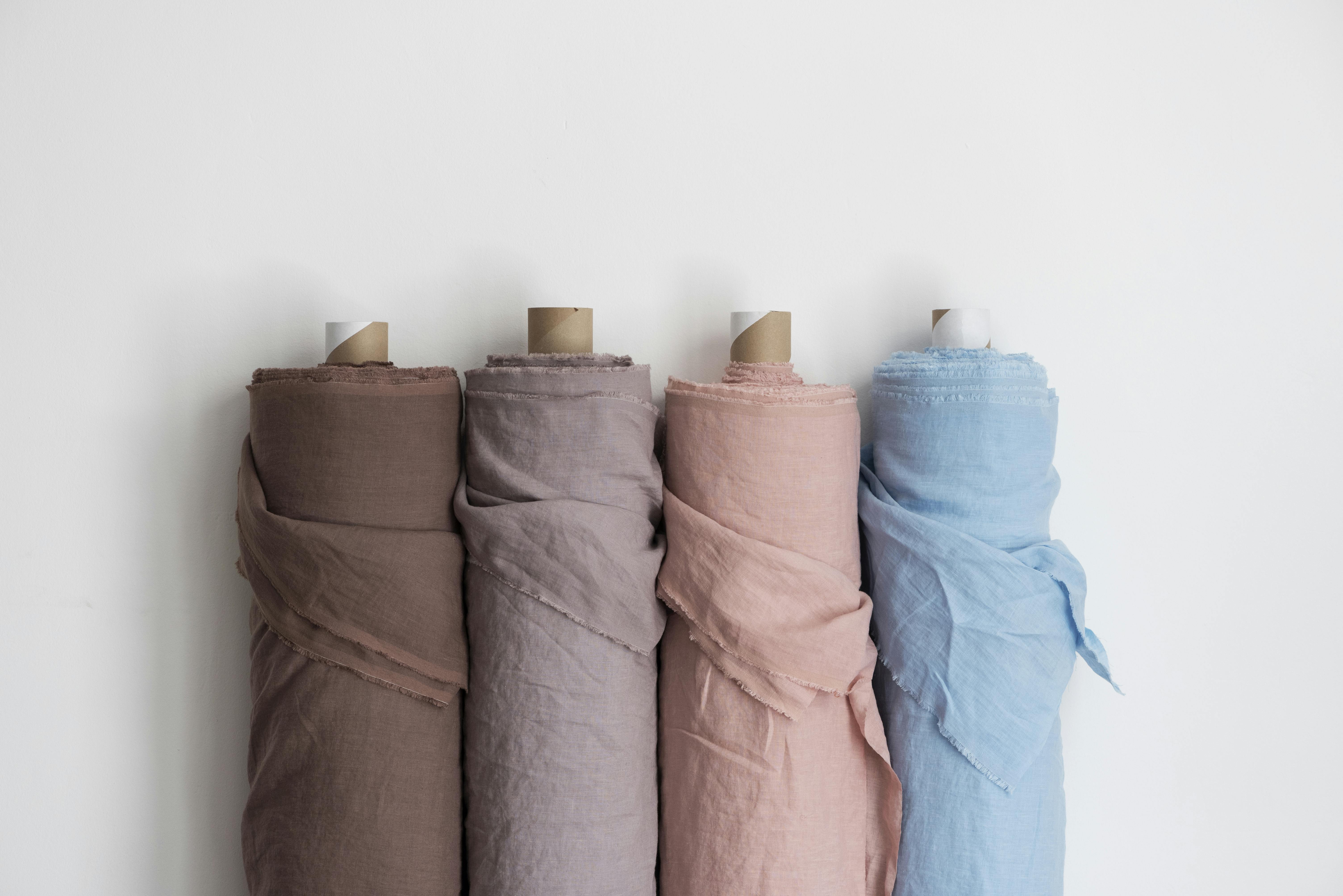 four rolls of linen fabric lined up