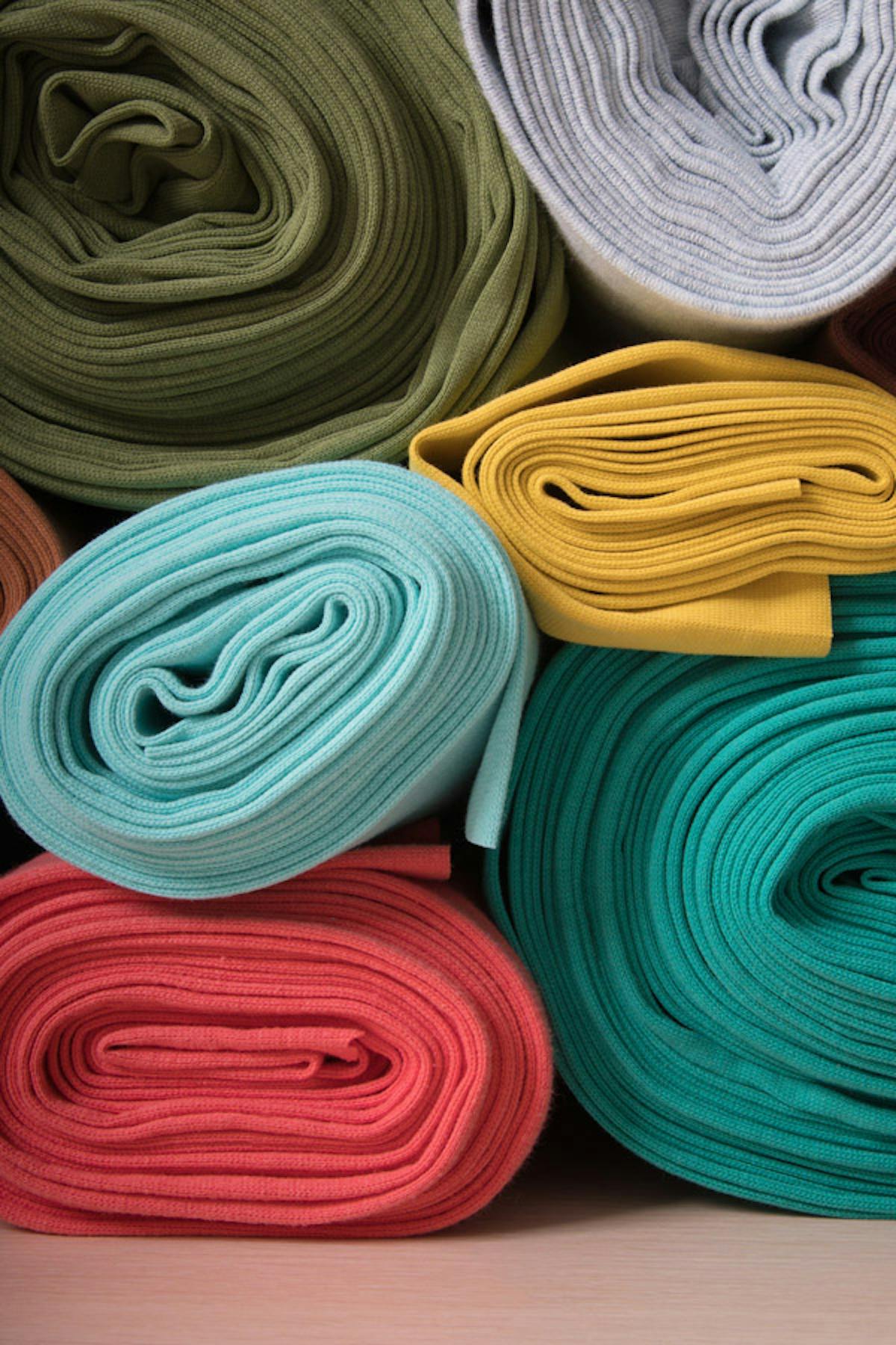  rotoli di tessuti a maglia multicolore impilati l'uno sull'altro