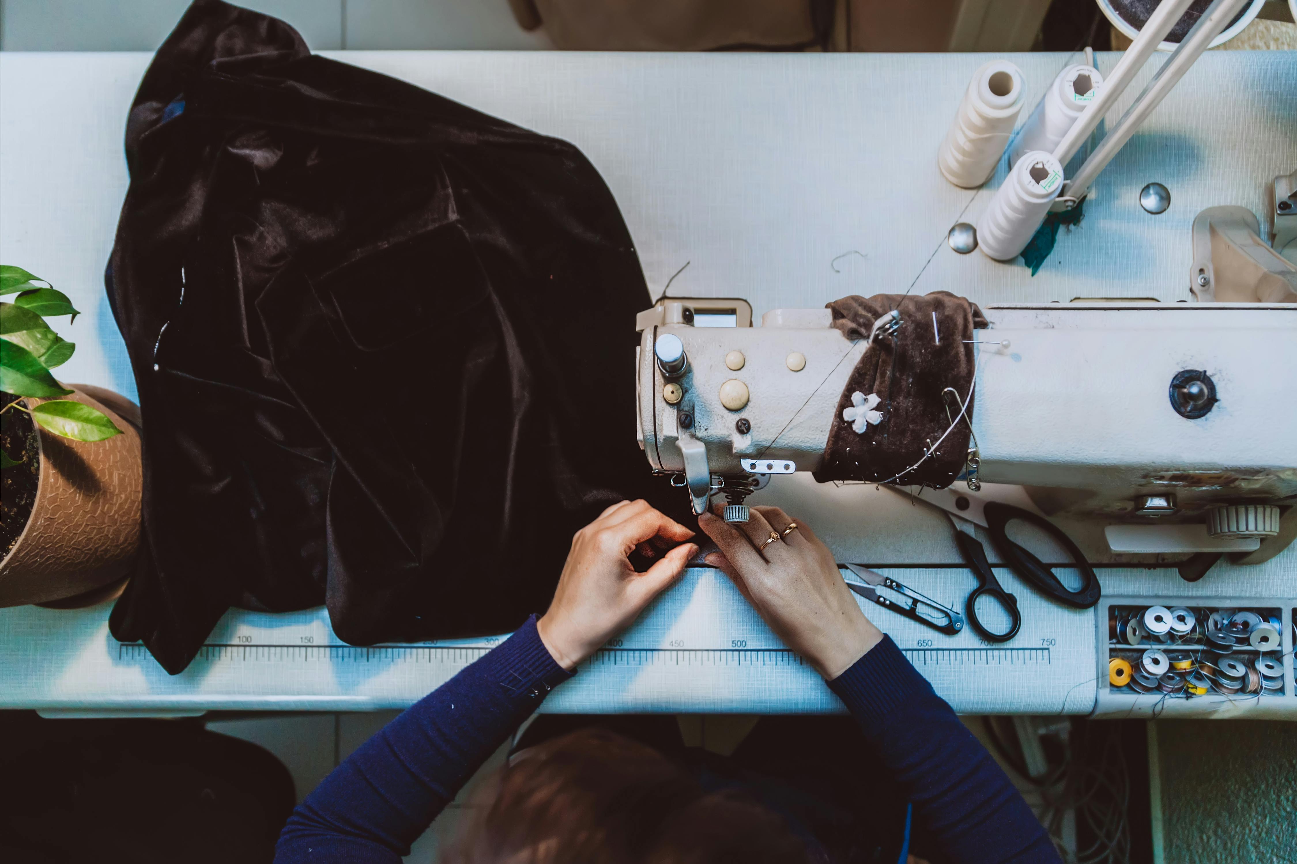  birds eye photo of woman sewing velvet jacket on sewing maching