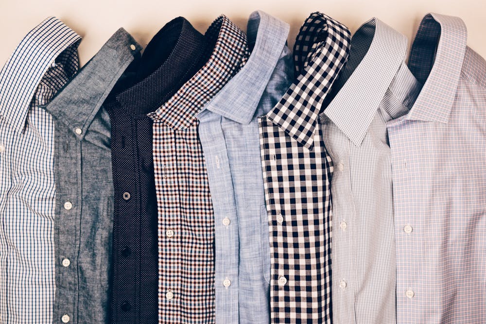 photograph of mens shirts folded and lined up in a row photograph of mens shirts folded and lined up in a row