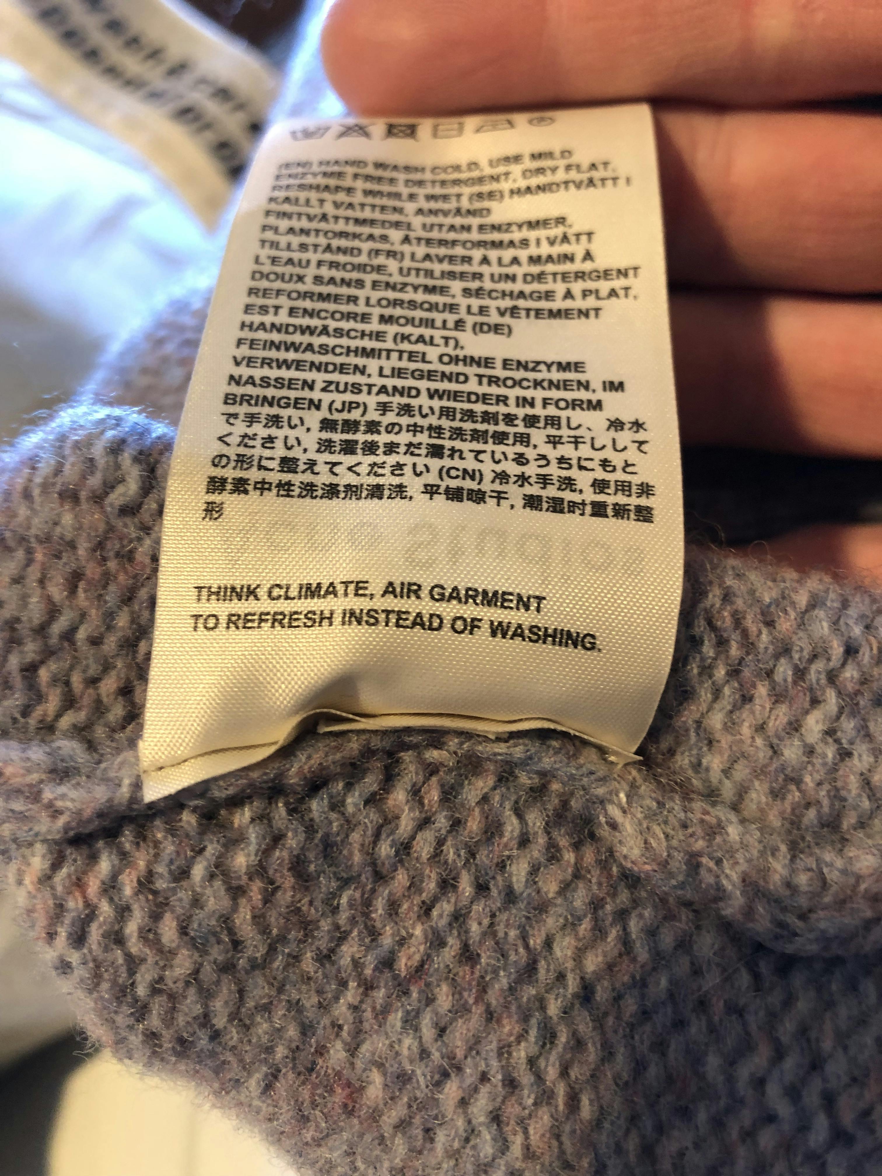  tekst van een waslabel met de aangepaste tekst &quot;Denk aan het klimaat. Lucht je kledingstuk in plaats van het te wassen om het te verfrissen.&quot;