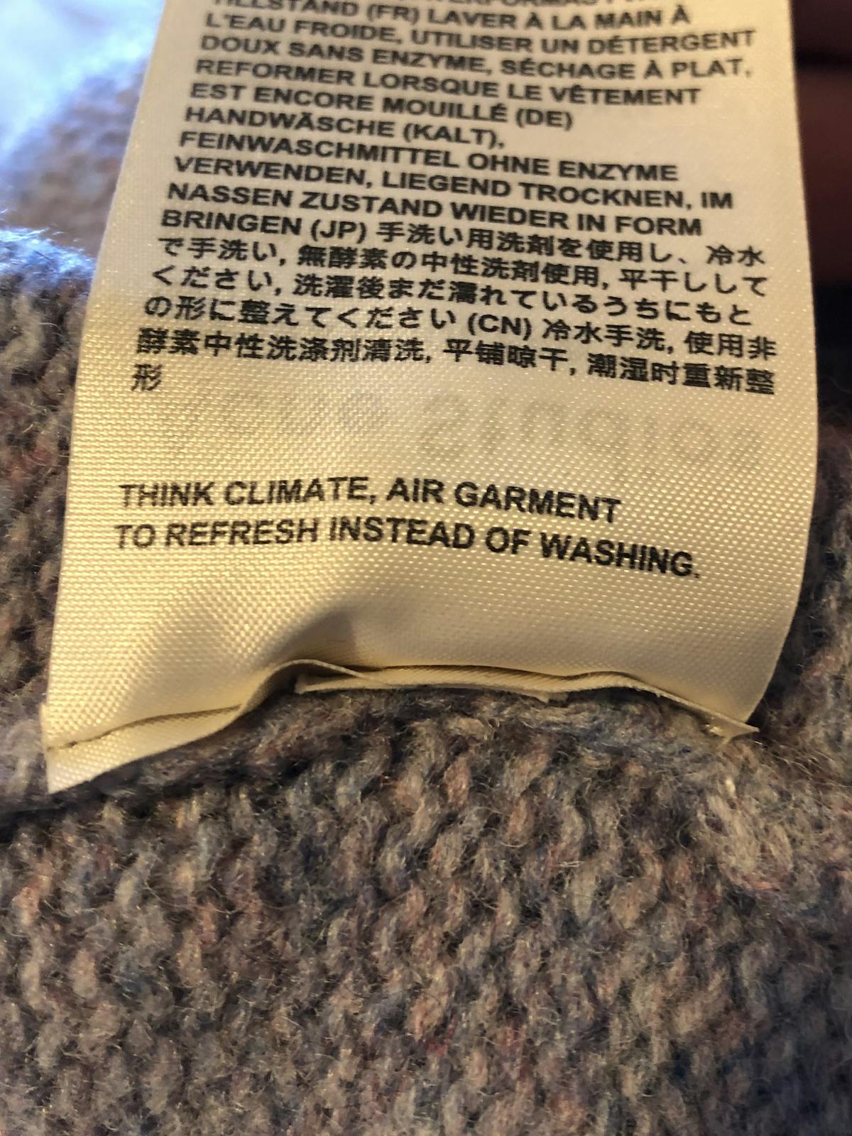  frase di un'etichetta di manutenzione realizzata con testo personalizzato "Pensa all'ambiente. Lascia il capo all'aria aperta invece di lavarlo"