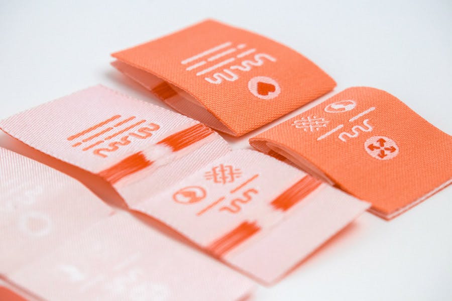  Anverso y reverso de etiquetas tejidas de Dutch Label Shop de color melocotón
