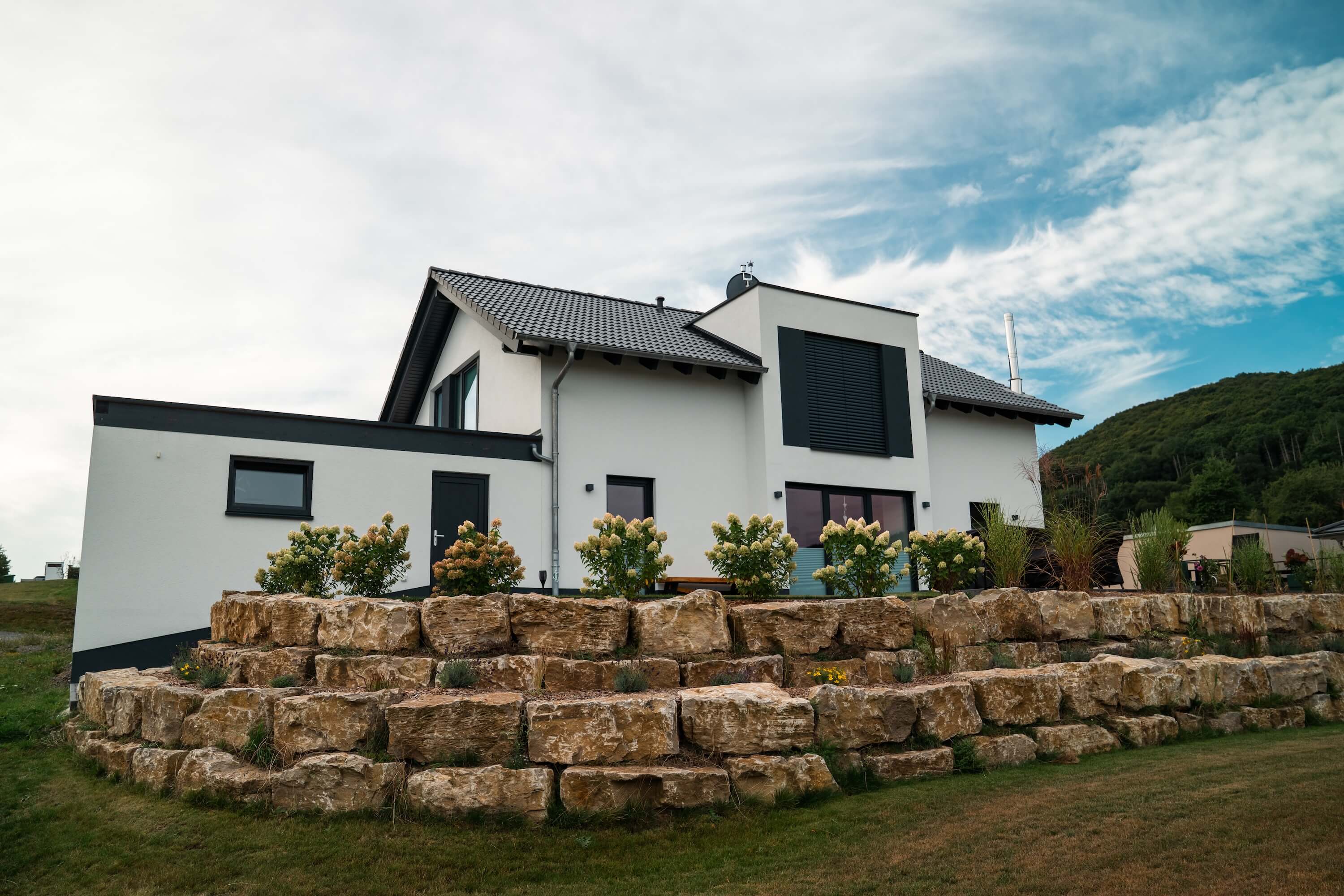 Außenansicht mit Garten eines Neubaus in Massivbauweise