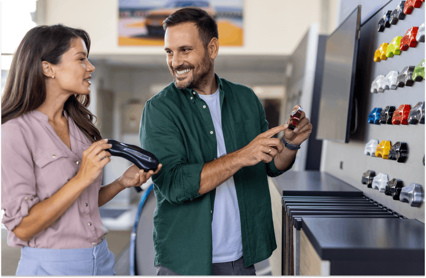 Man and woman discussing new car colours in a car showroom