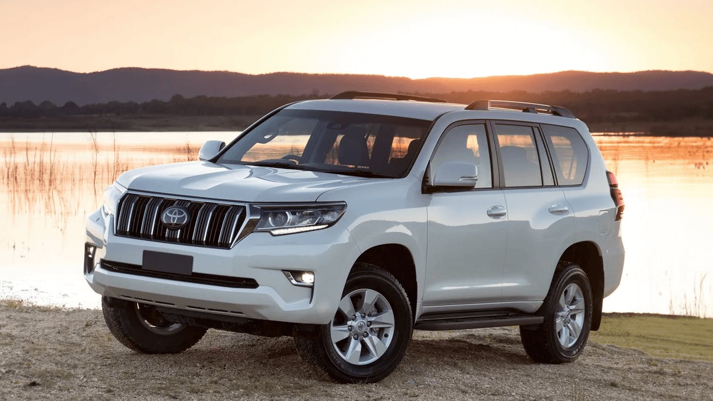 white toyota prado with water in background