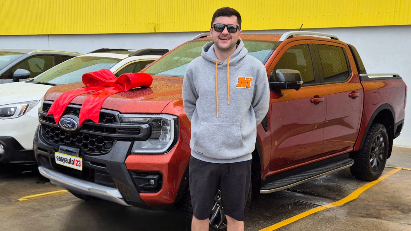 Happy male used car customer Michael Milligan with Ford Ranger at easyauto123 used car superstore