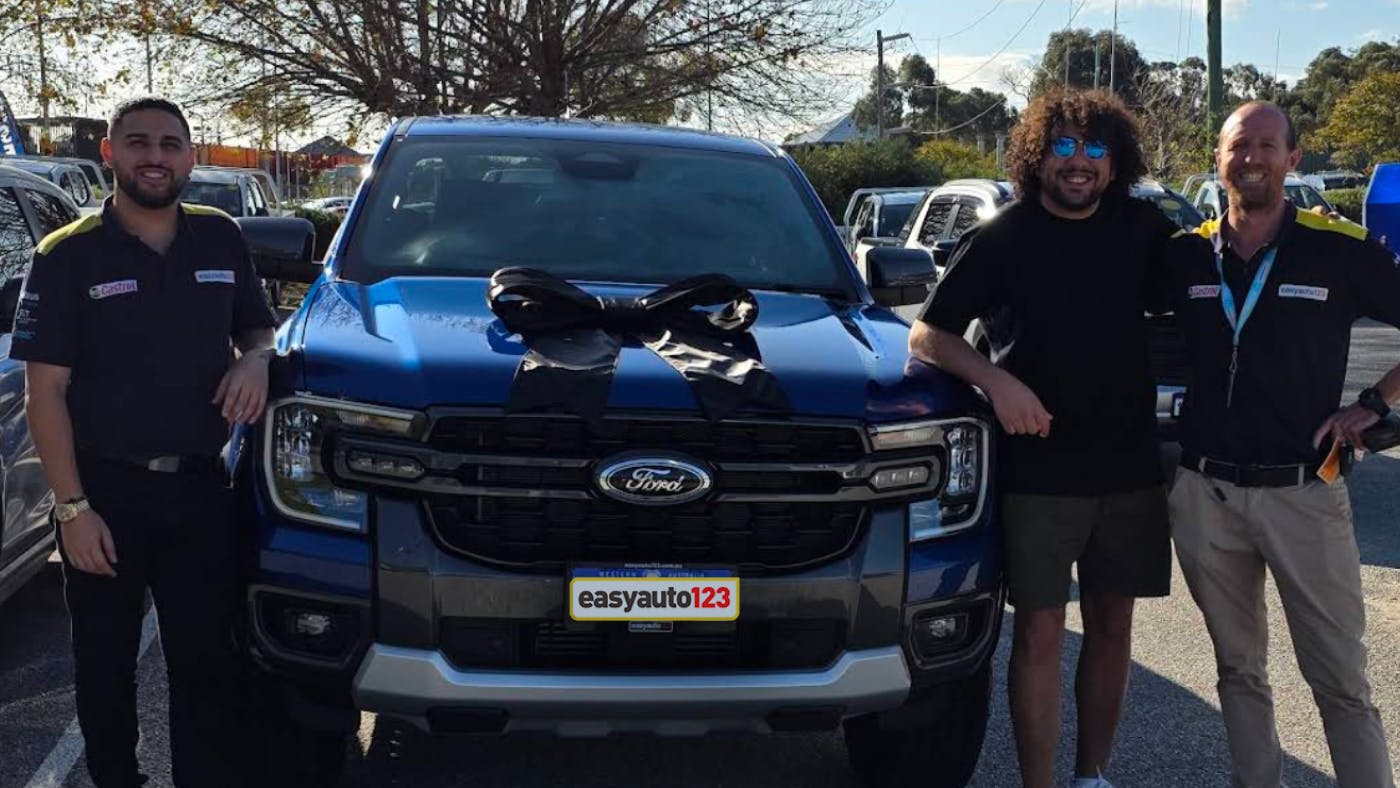 Happy male used car customer Jason Awad with Ford Ranger at easyauto123 used car superstore