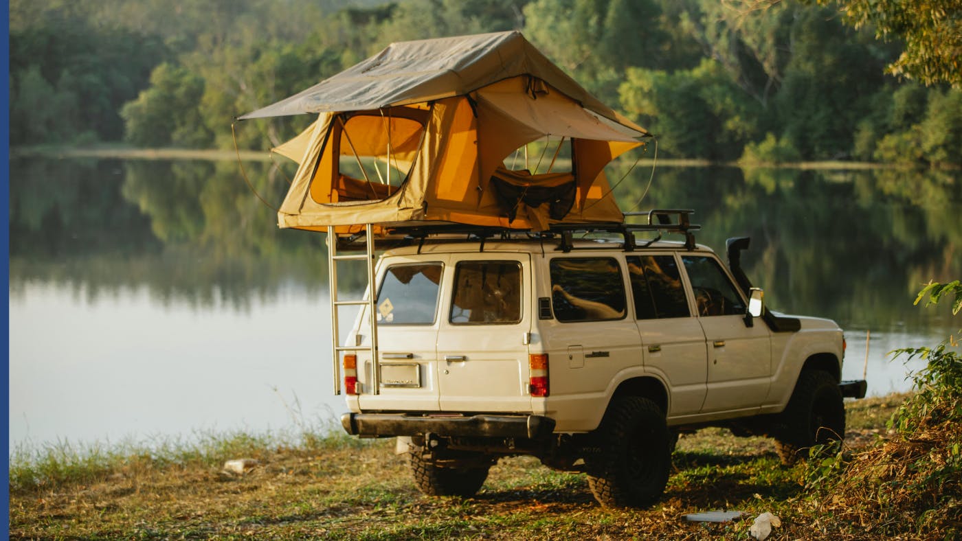 Toyota LandCruiser parked by lake with roof tent