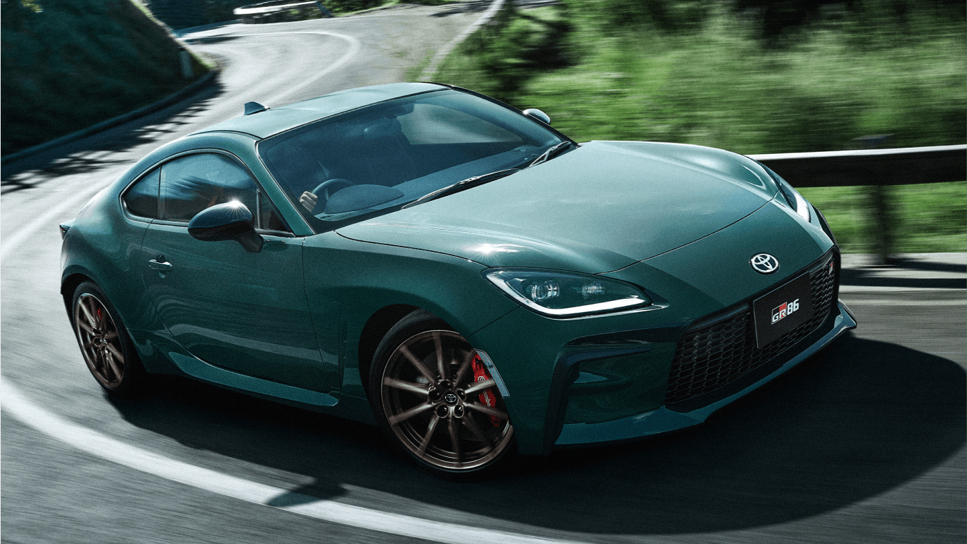 Image of green Toyota GR86 sportscar driving on twisty mountain road