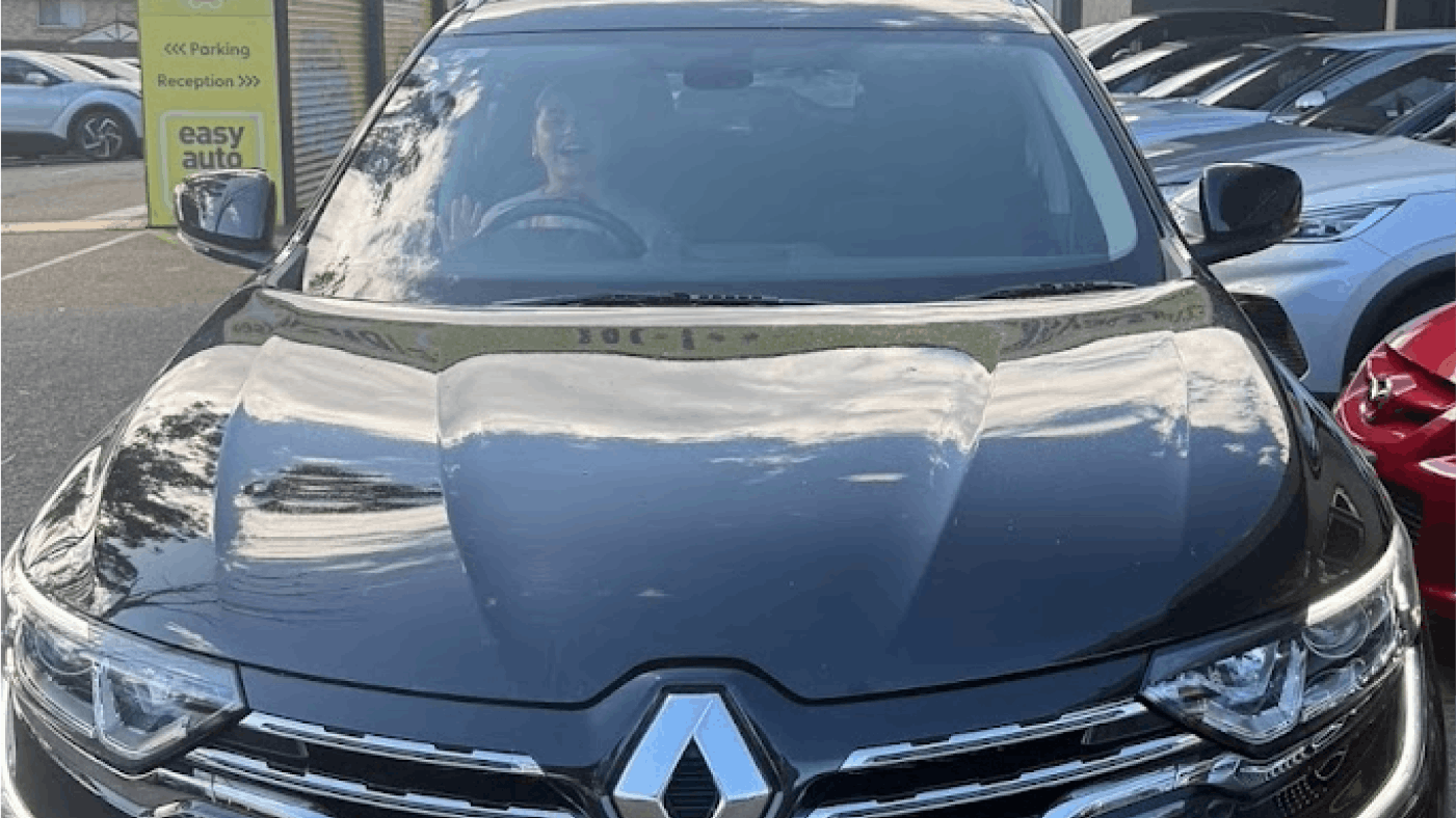 Happy easyauto123 customer waving through windscreen