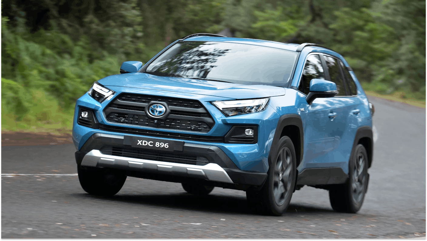 Blue Toyota RAV4 driving left to right on country road