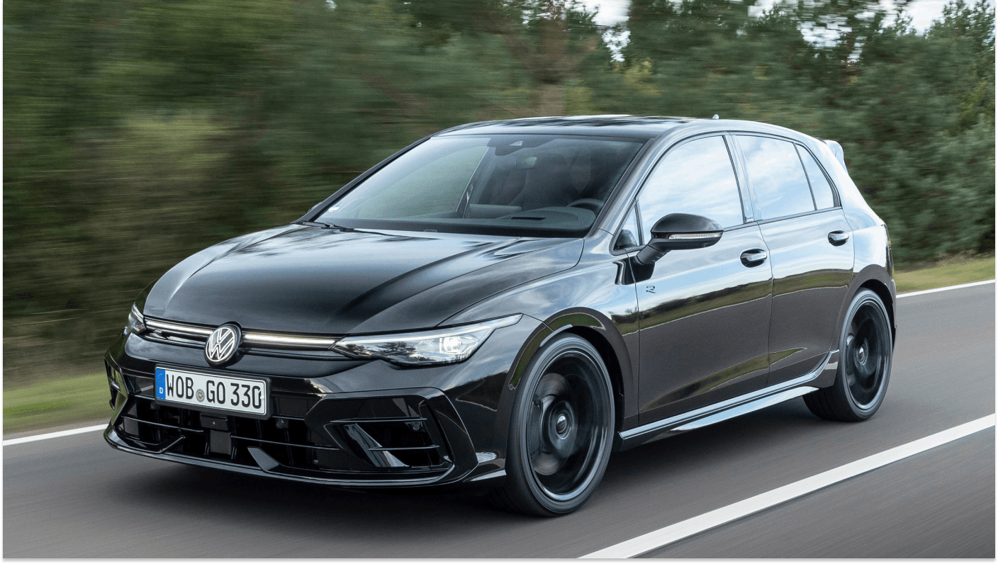 Black Volkswagen Golf driving on country road travelling from right to left