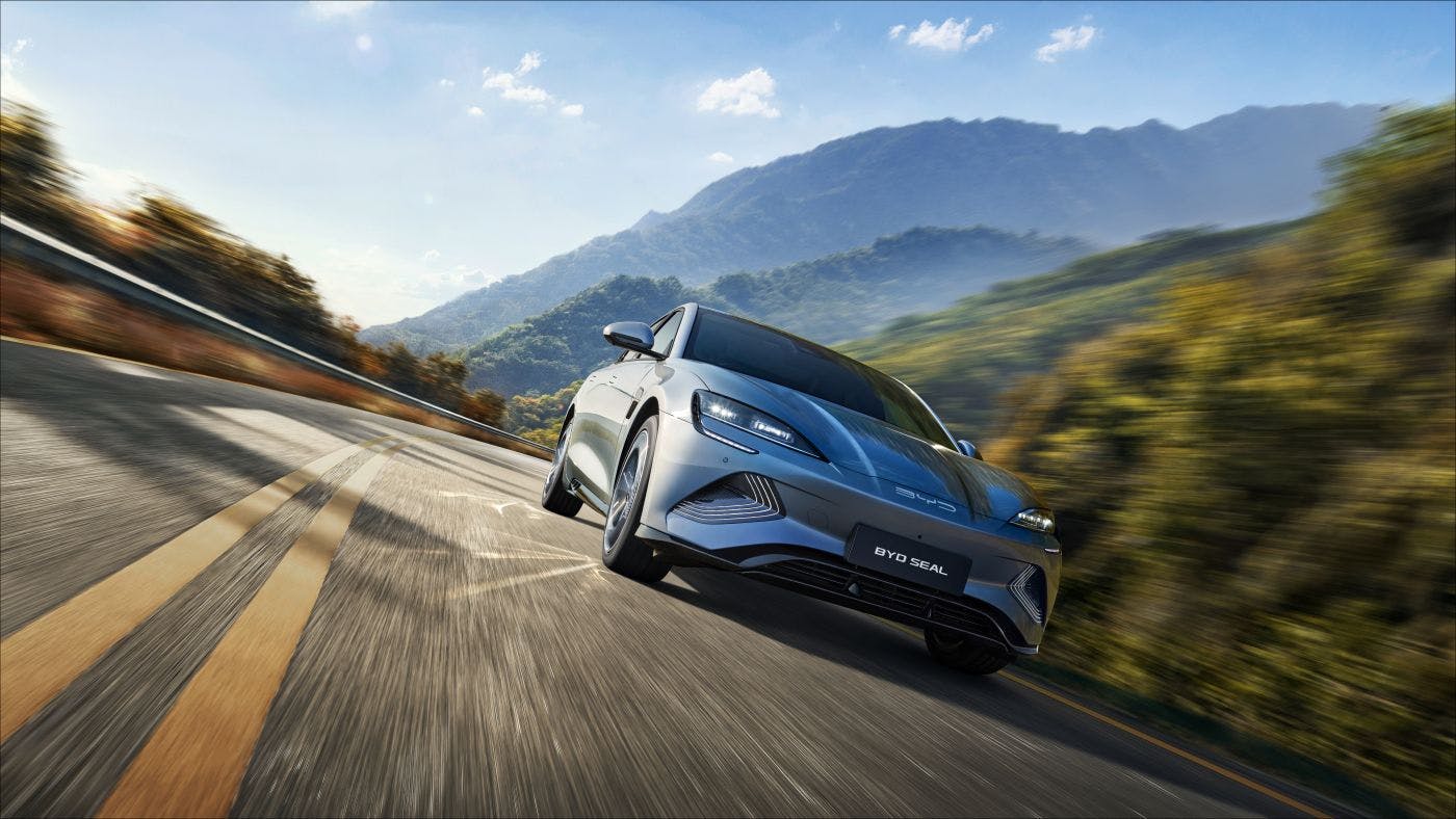 Electric vehicle driving at high speed with mountains in the background