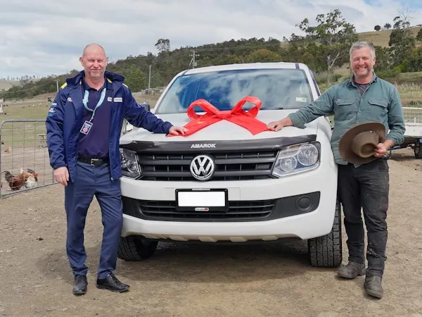 A man wearing an easyauto123 uniform presenting a Volkswagen Amarok to a second man for Cars for Good