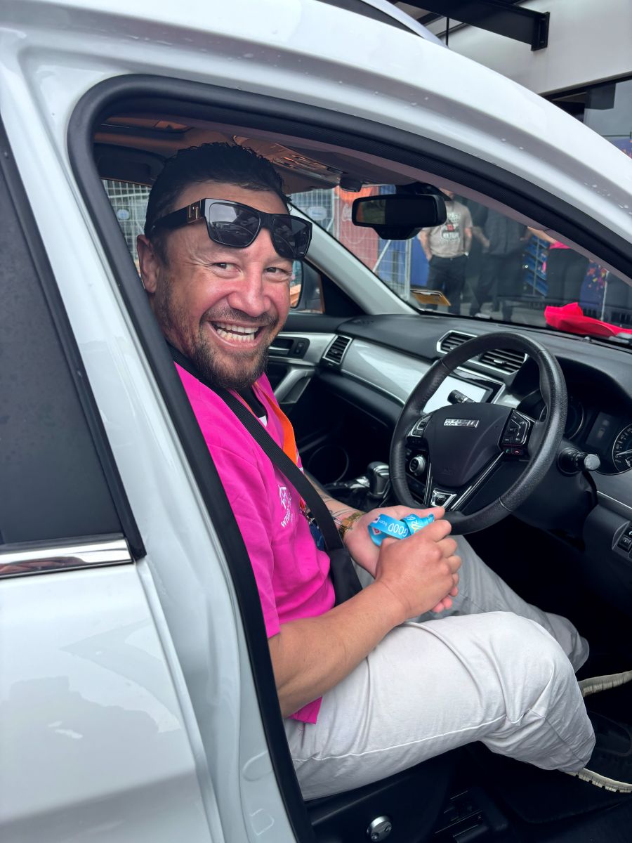 A happy man seated behind the wheel of a car