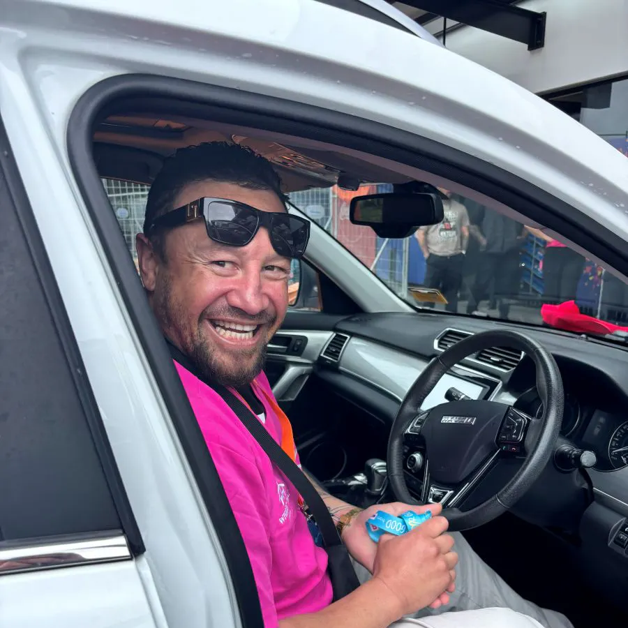 A happy man seated behind the wheel of a car
