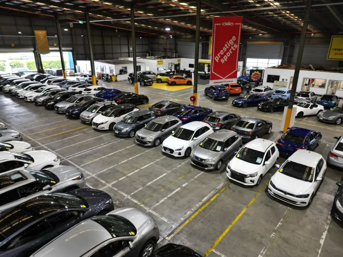 Aerial view of vehicles lined up inside used car dealership.
