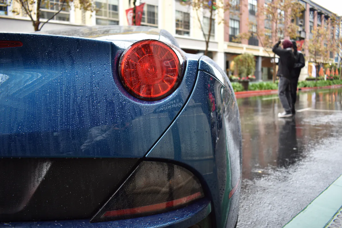 Close up on blue Electric Vehicle parked on a wet street