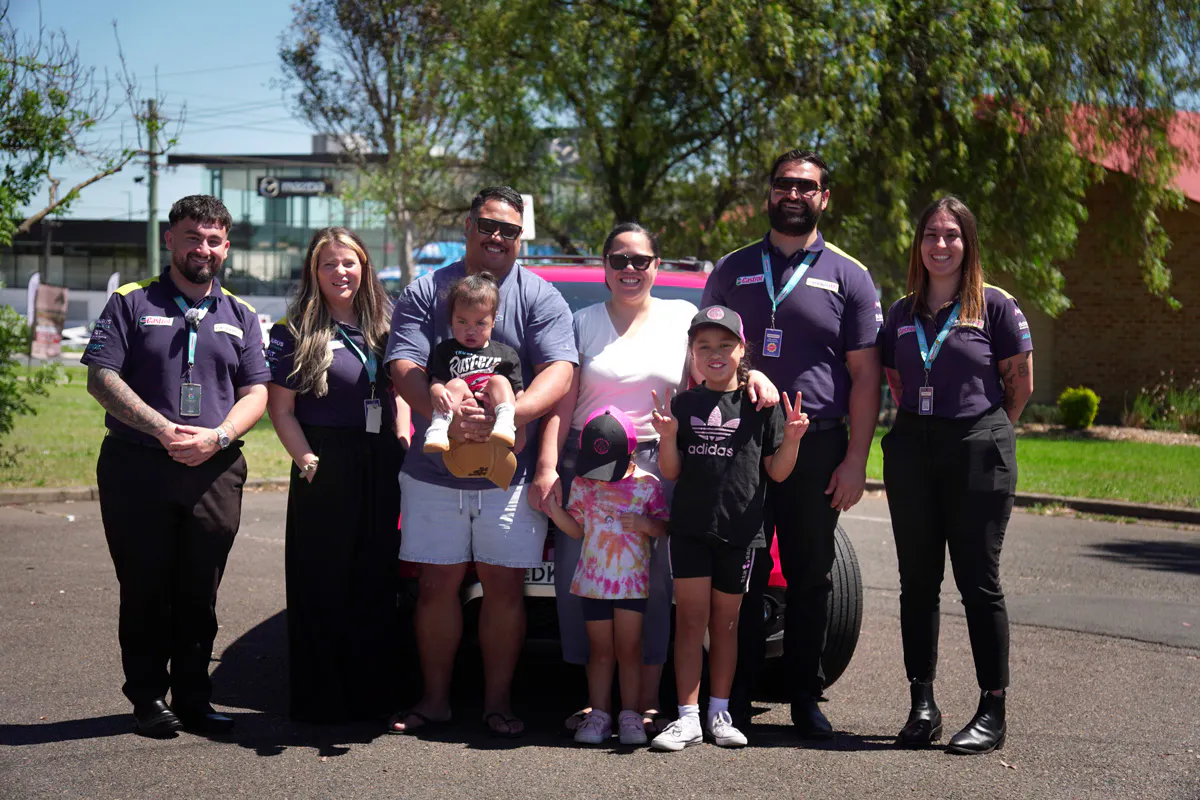A family standing in front of a car along with easyauto123 staff
