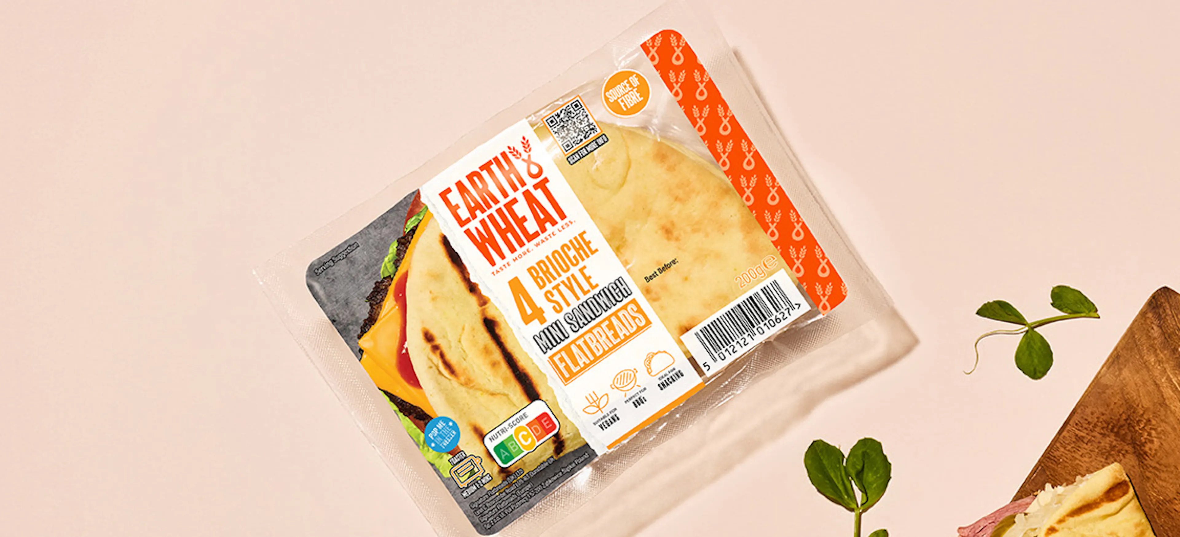 Hand holding Folded brioche style flatbreads filled with ham and cheese plus extra on wooden chopping board