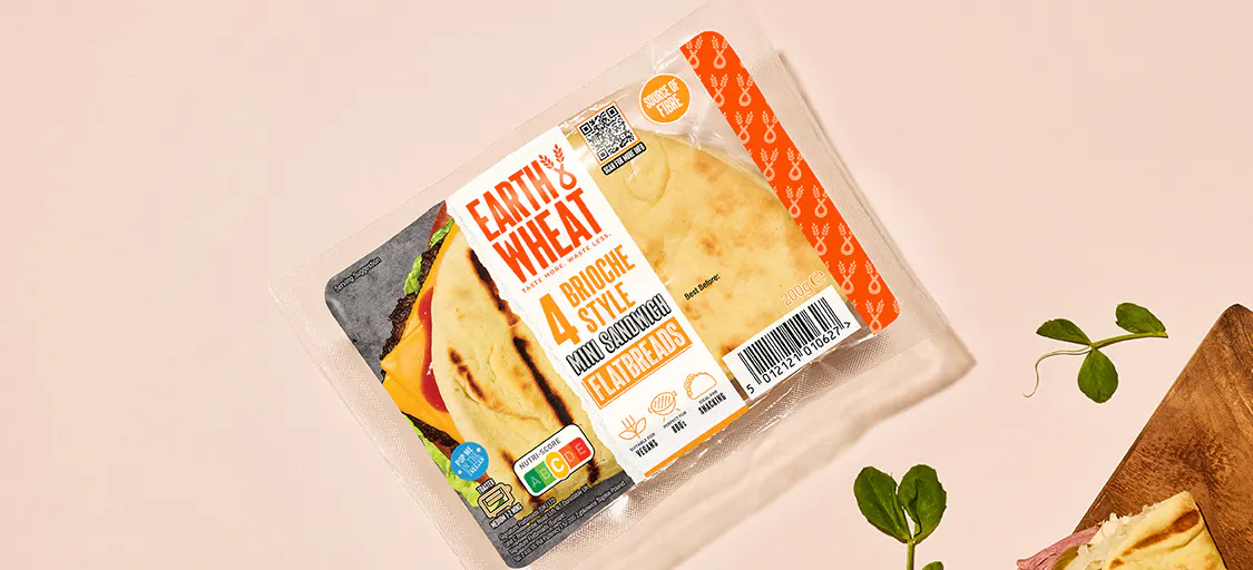 Hand holding Folded brioche style flatbreads filled with ham and cheese plus extra on wooden chopping board
