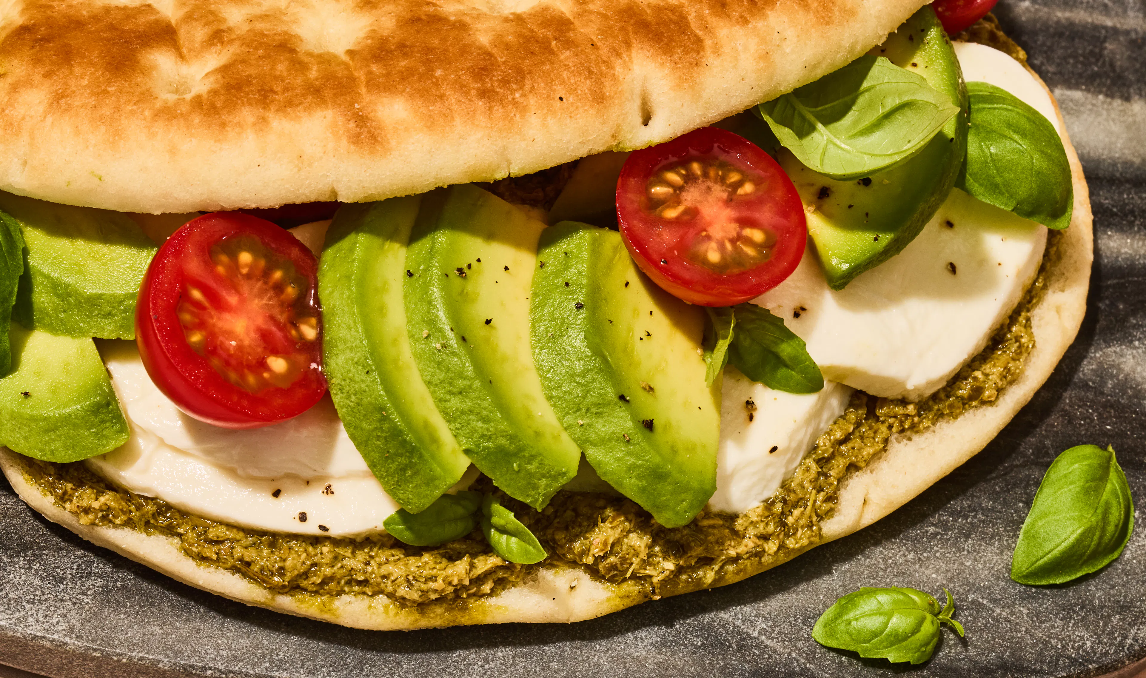 Close up of Focaccia sandwich with chicken, avocado and tomato filling.