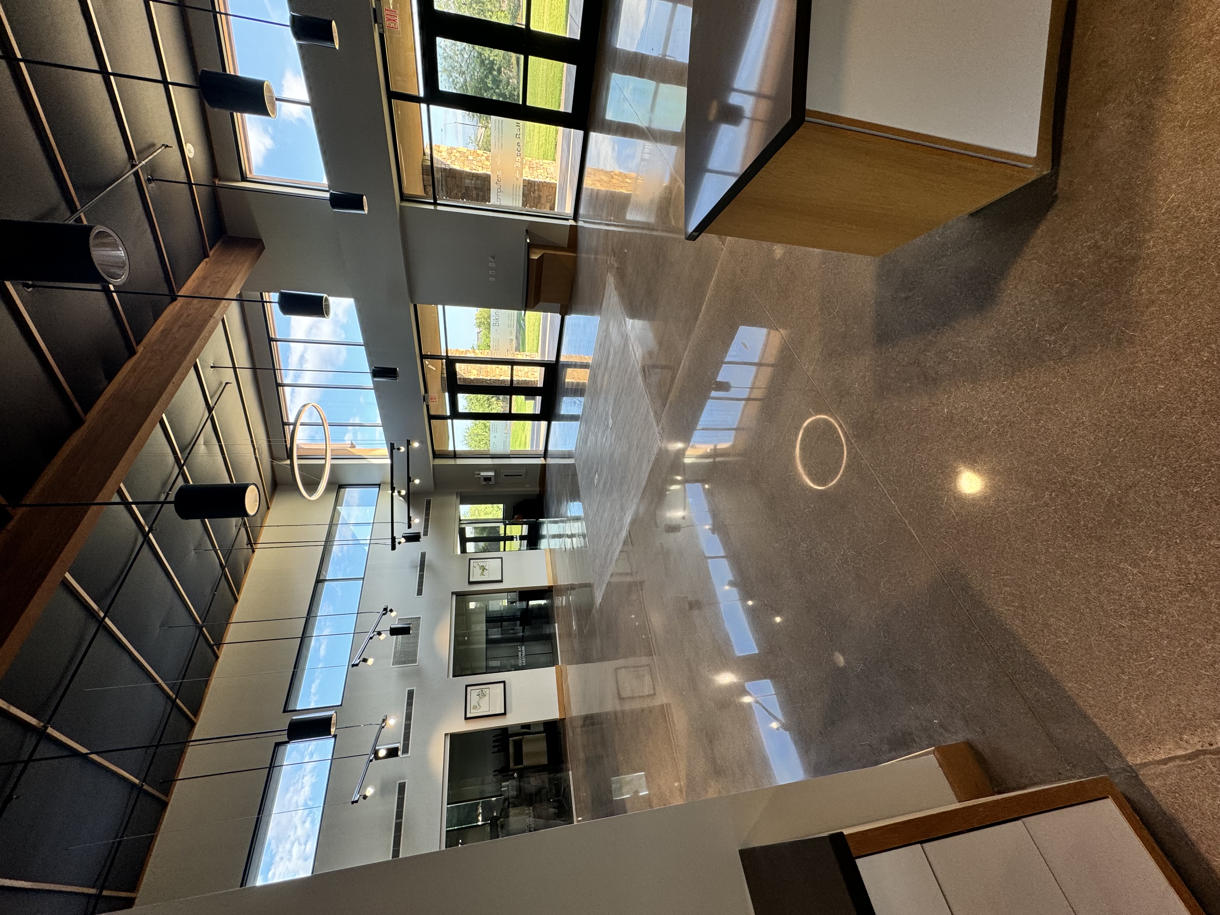 Commercial interior lobby with glossy metallic epoxy floor coating wood beams and large windows