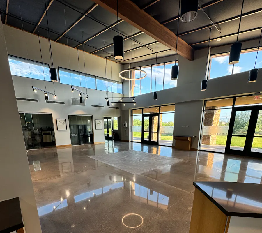 Commercial interior lobby with glossy metallic epoxy floor coating wood beams and large windows