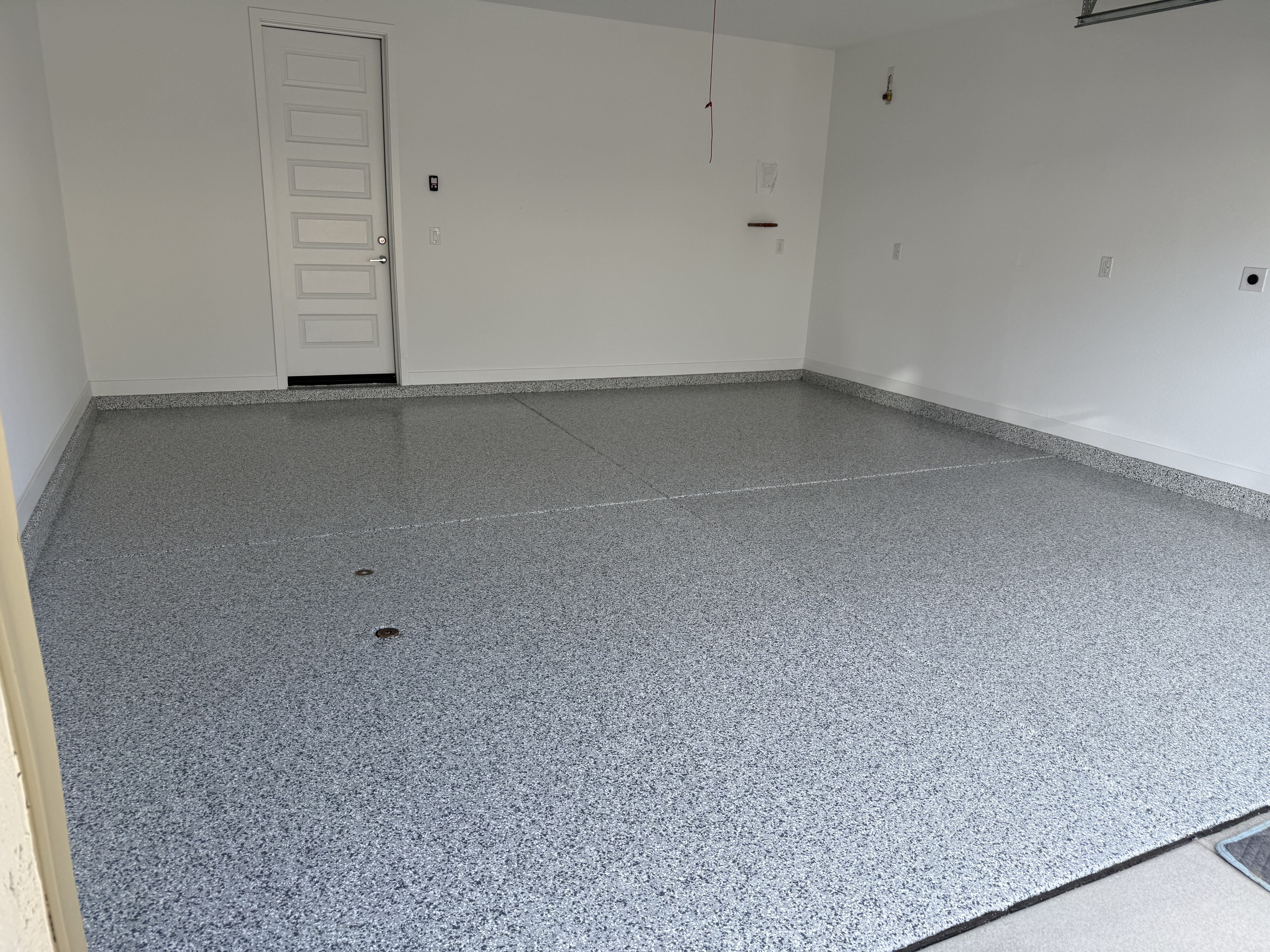 Residential garage with flake epoxy floor coating clean white door
