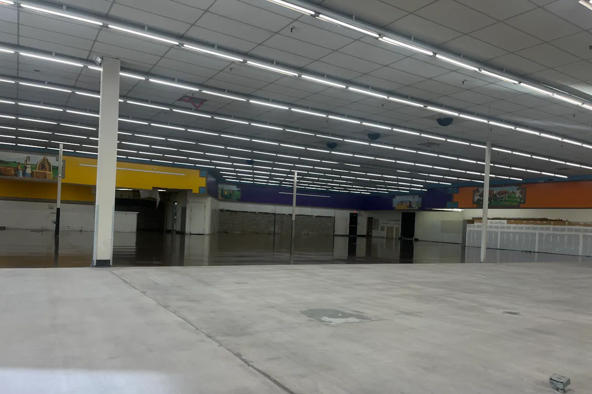 Commercial large retail space before coating bare concrete fluorescent lights colorful walls