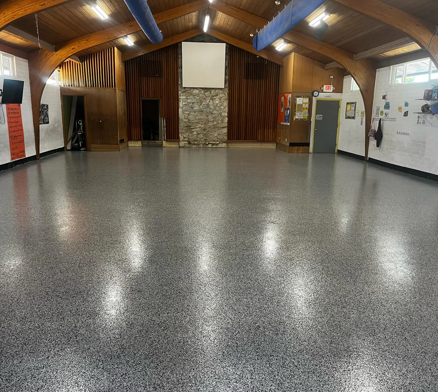 Commercial venue church interior with glossy flake epoxy floor coating wood beam ceiling stone
