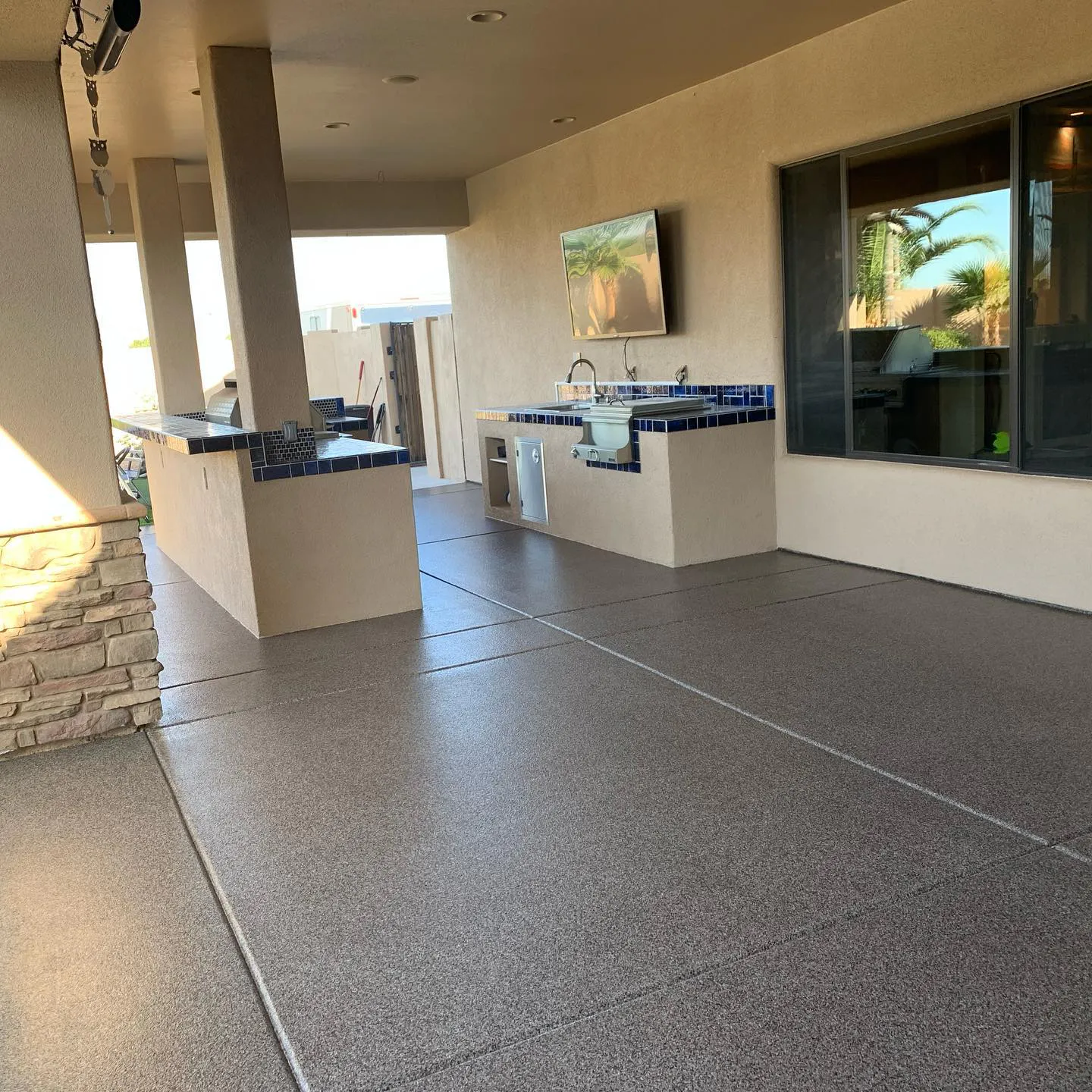 Residential outdoor kitchen patio with flake polyaspartic floor coating