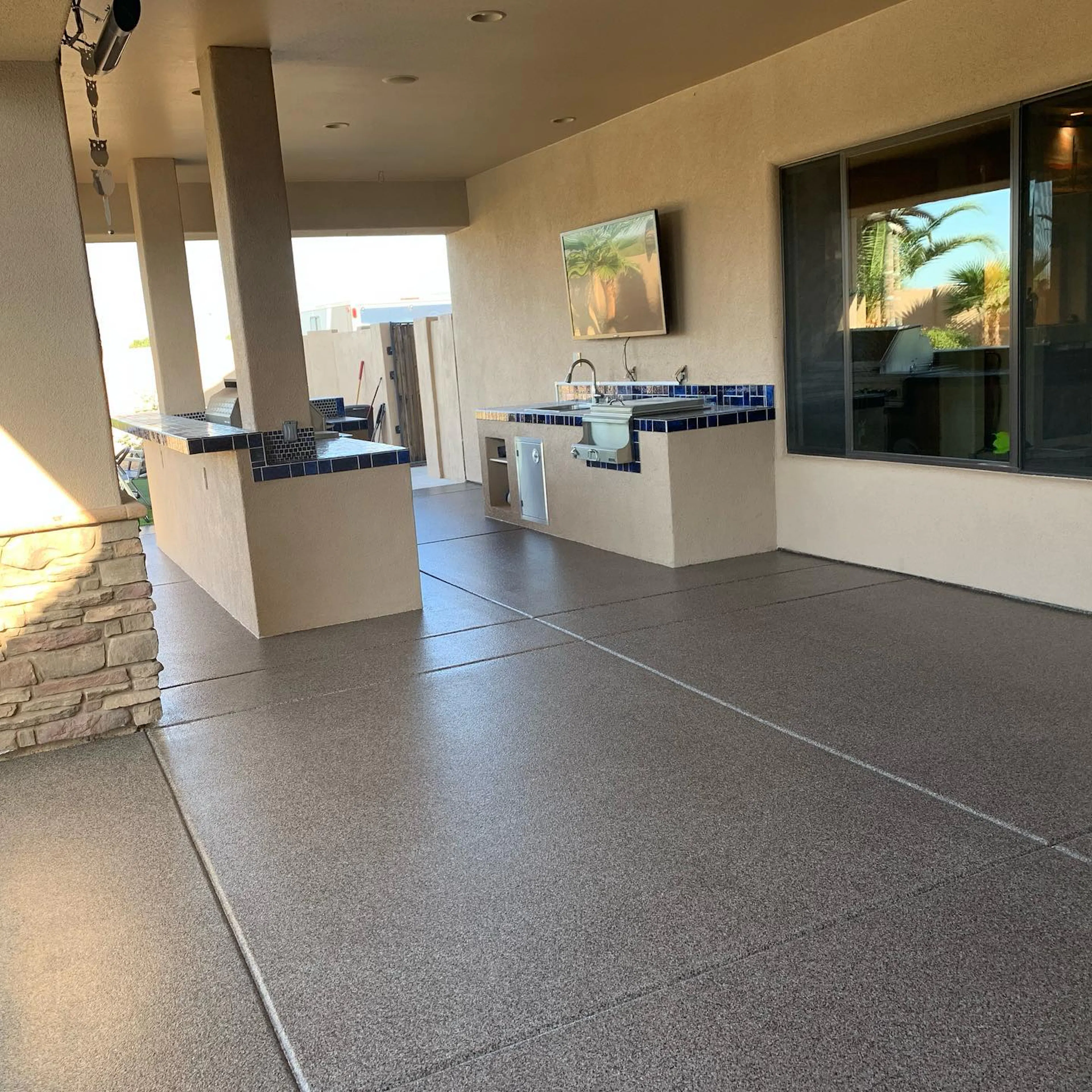 Residential outdoor kitchen patio with flake polyaspartic floor coating