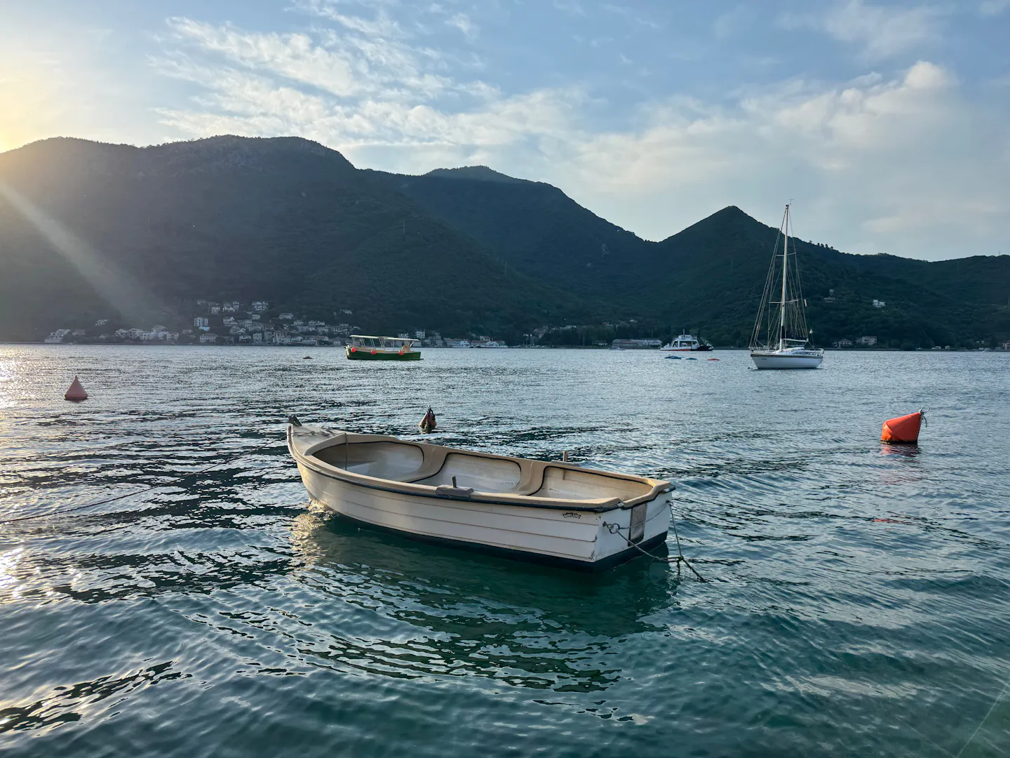 Small boat on calm water below the mountains near Herceg Novi, Montenegro