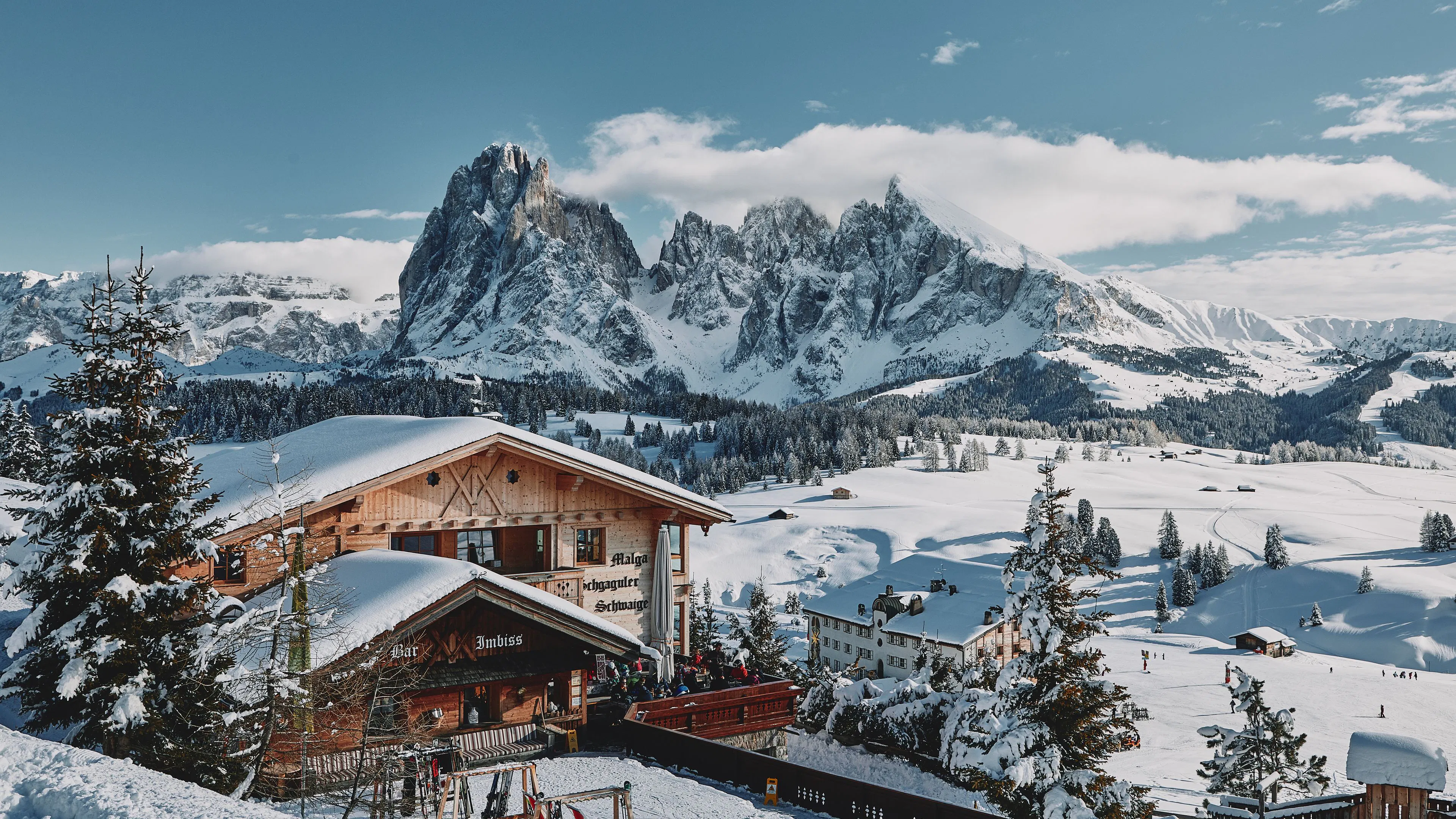 Snowy Alpine chalet beneath the dramatic Dolomites in a European winter resort