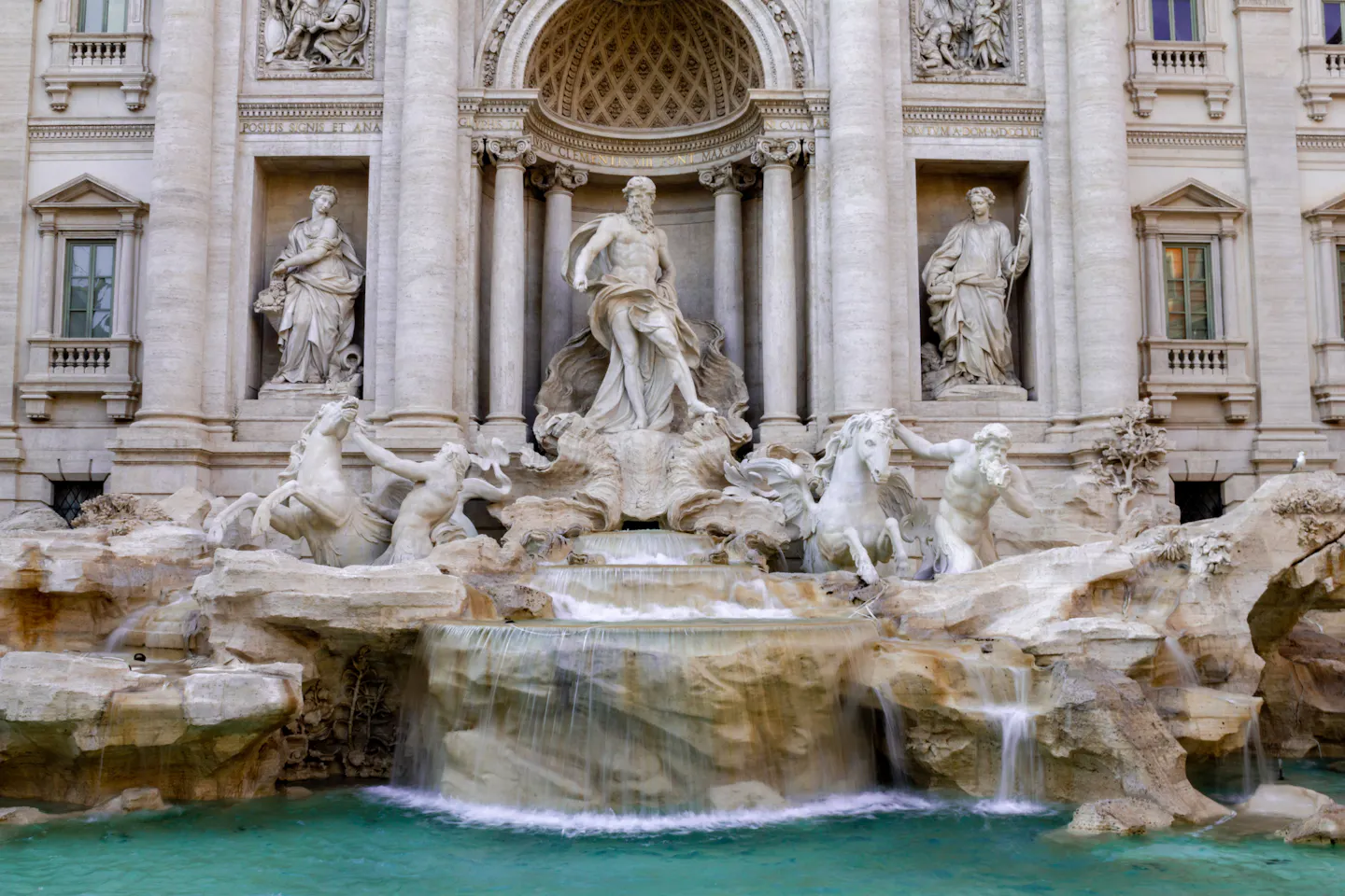 Oceanus and the sea horses of the Trevi Fountain above cascading water and a turquoise basin