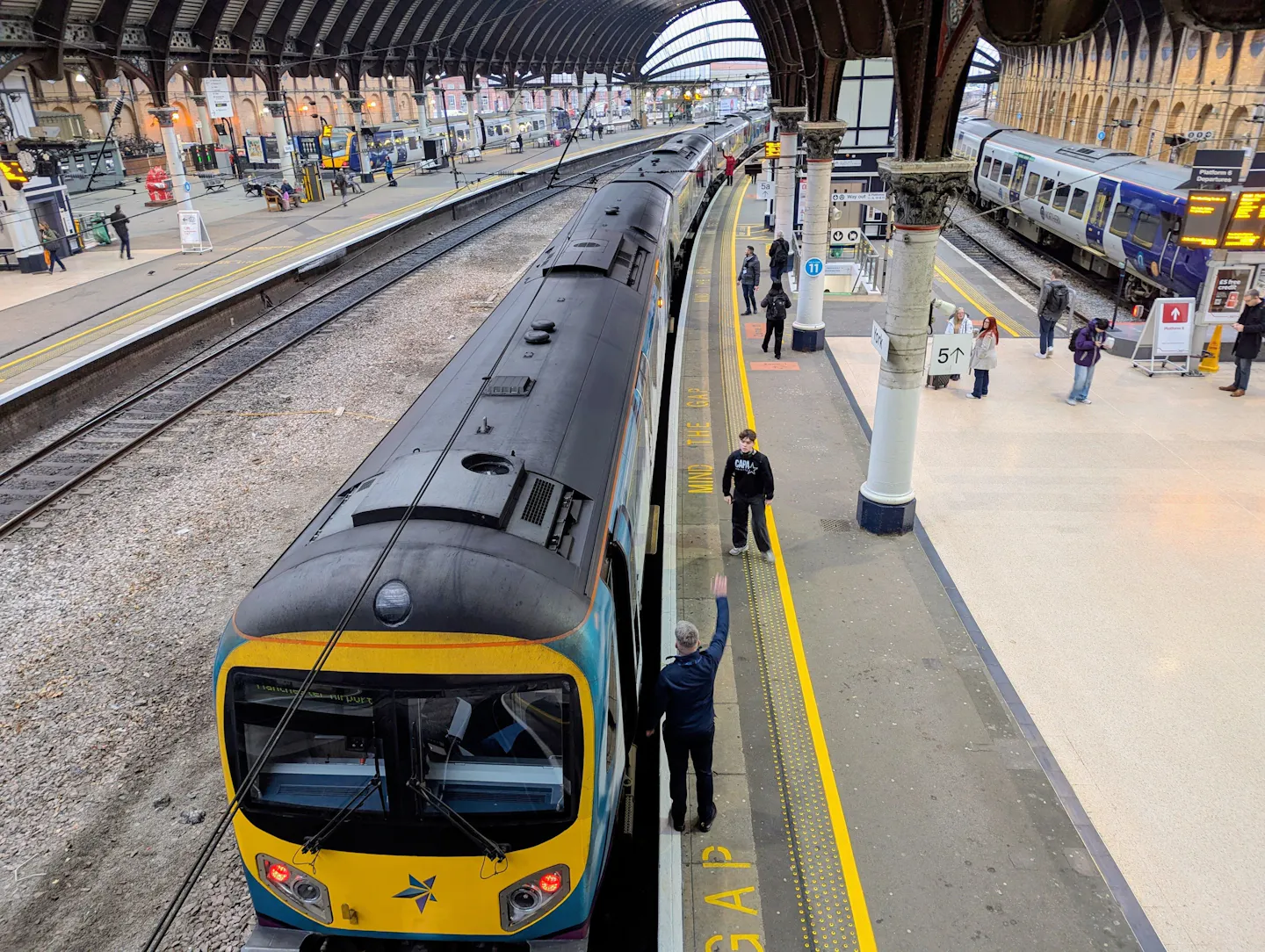 Passenger trains at the platforms of a large covered railway station