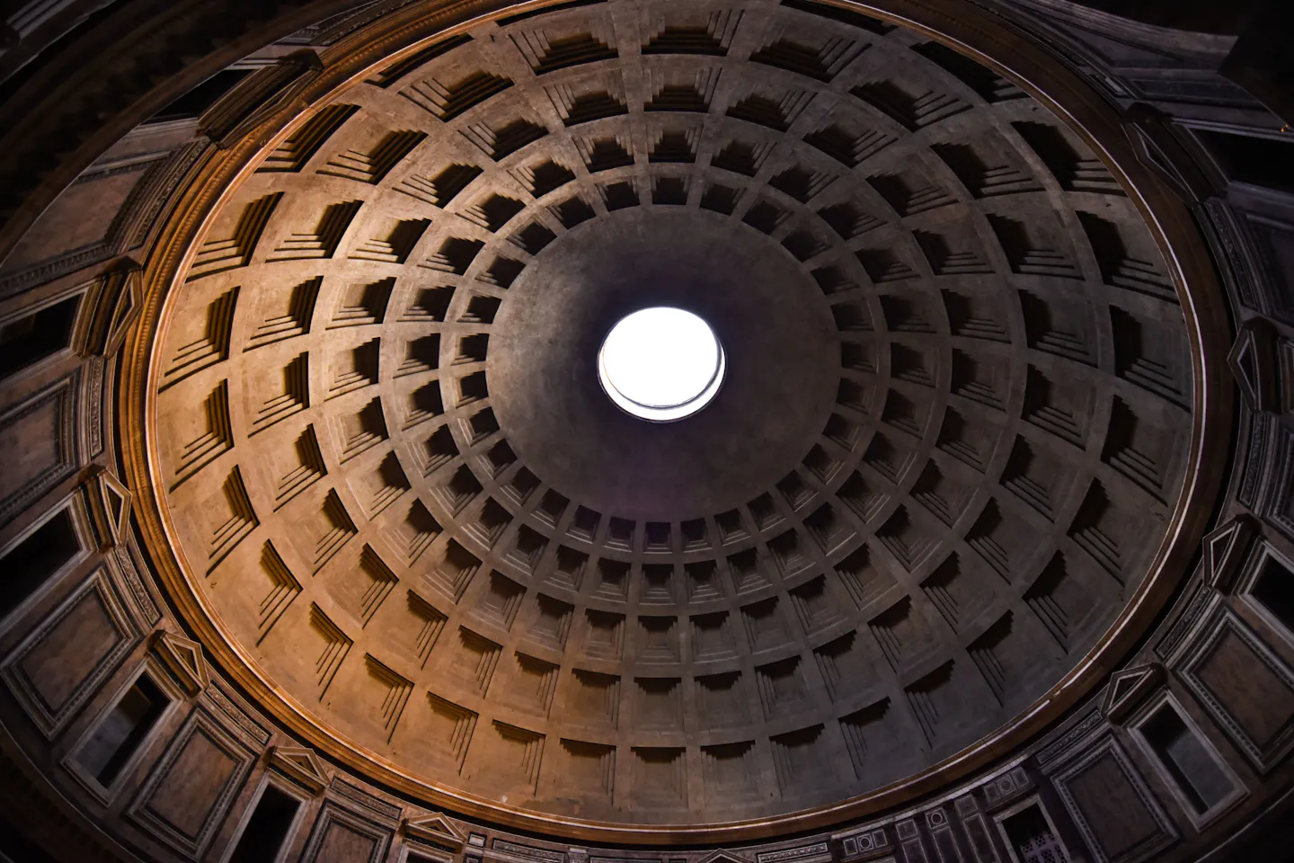 The coffered concrete dome of the Pantheon lit by daylight falling through its open central oculus