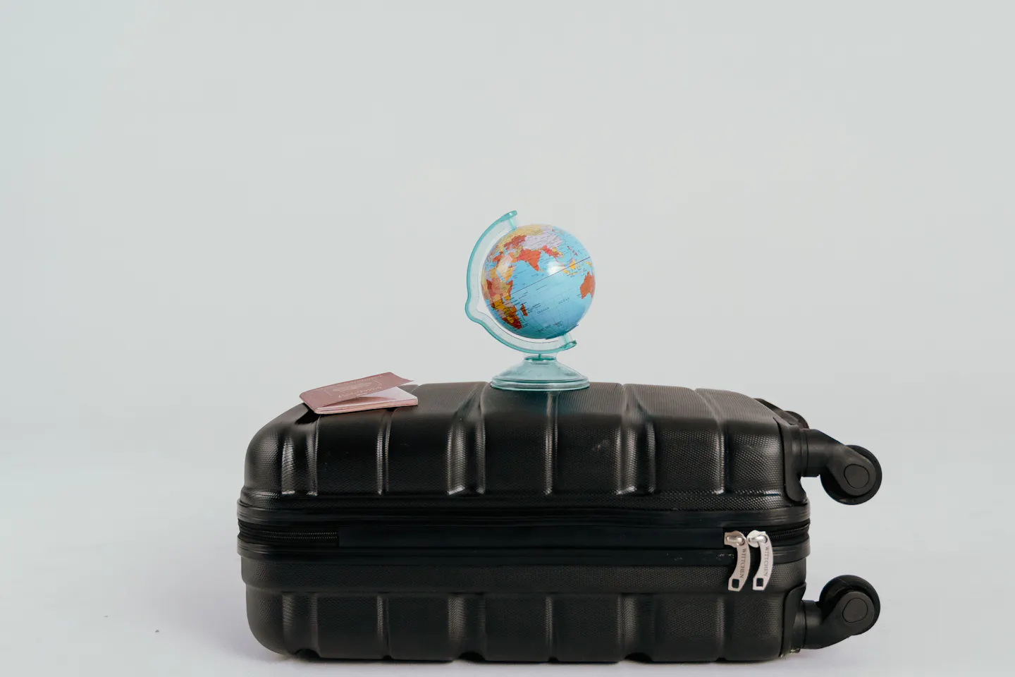 A black suitcase with a travel globe