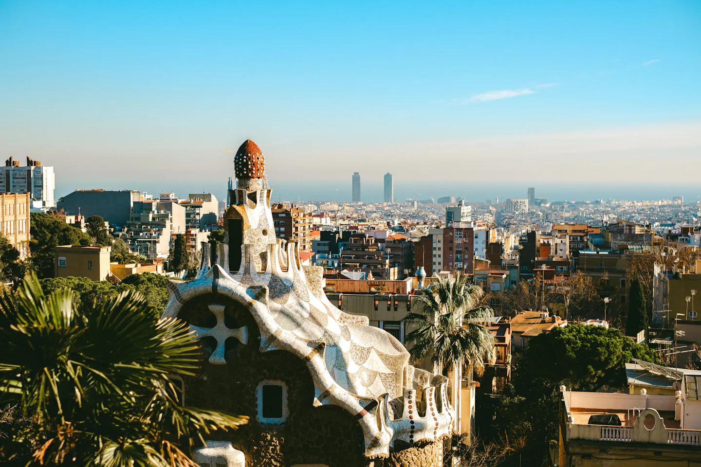 A mosaic-topped Gaudi pavilion at Park Guell above Barcelona's rooftops and the Mediterranean