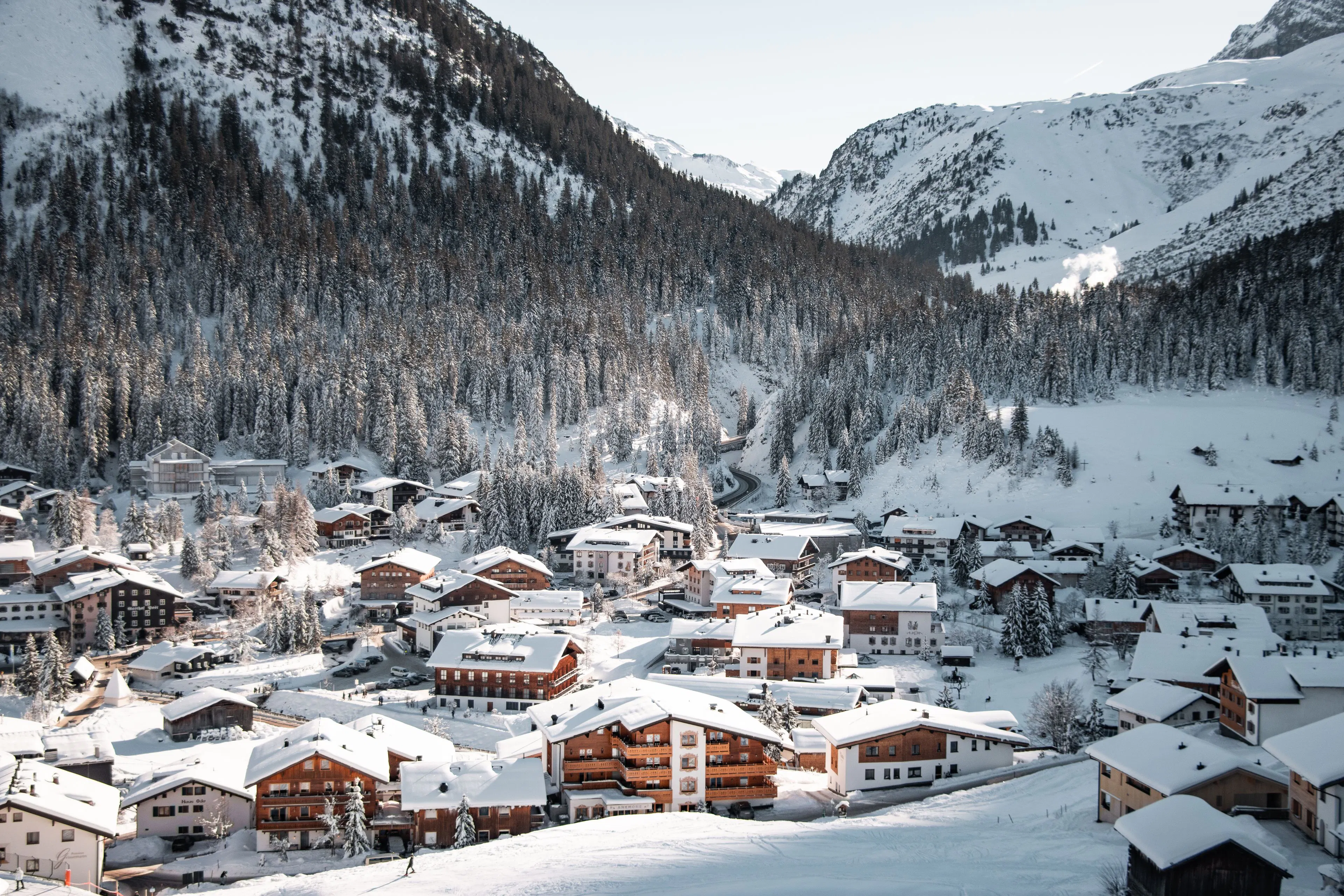 Snow-covered Alpine village nestled beneath mountain slopes at Christmas