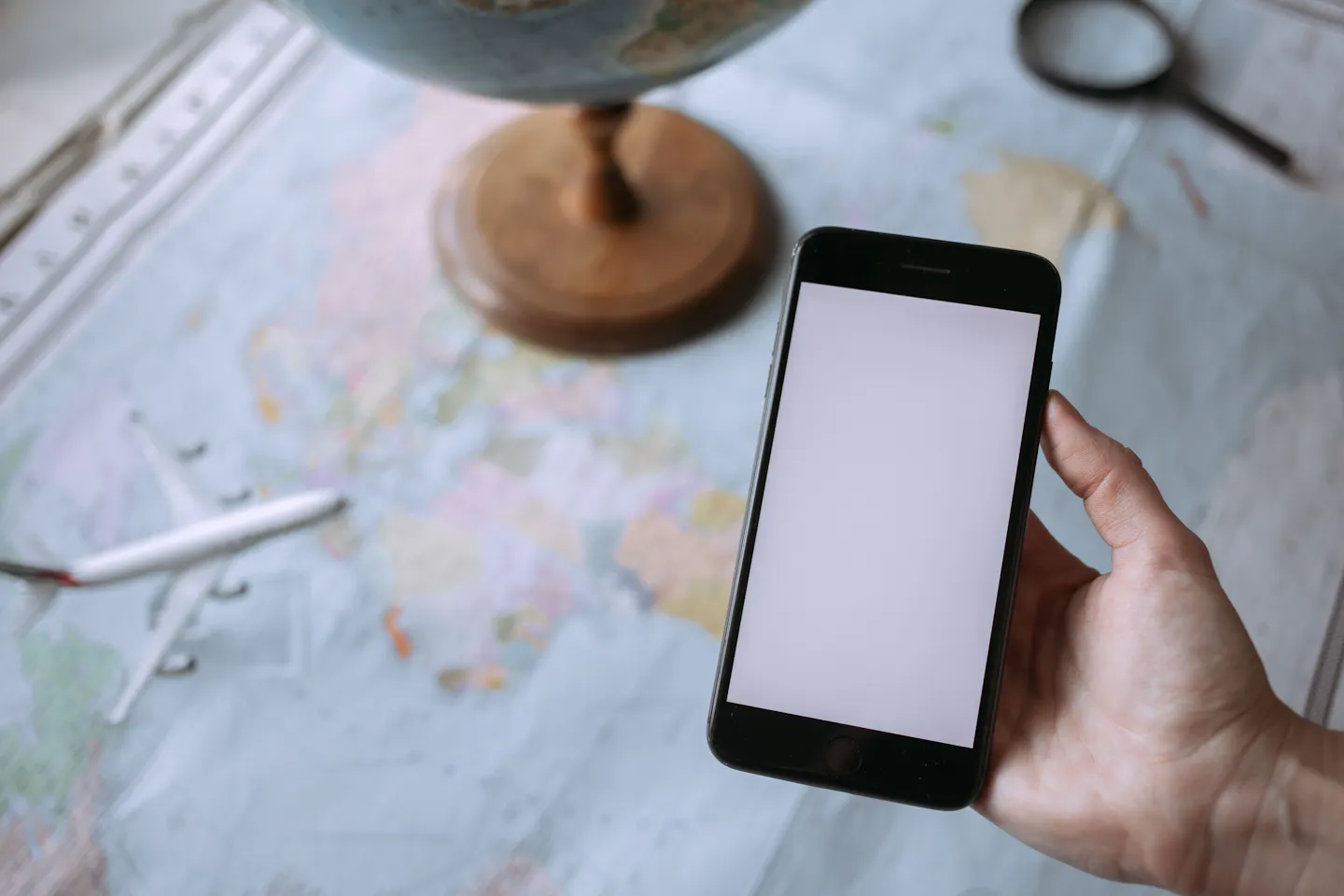 A smartphone and globe on a world map