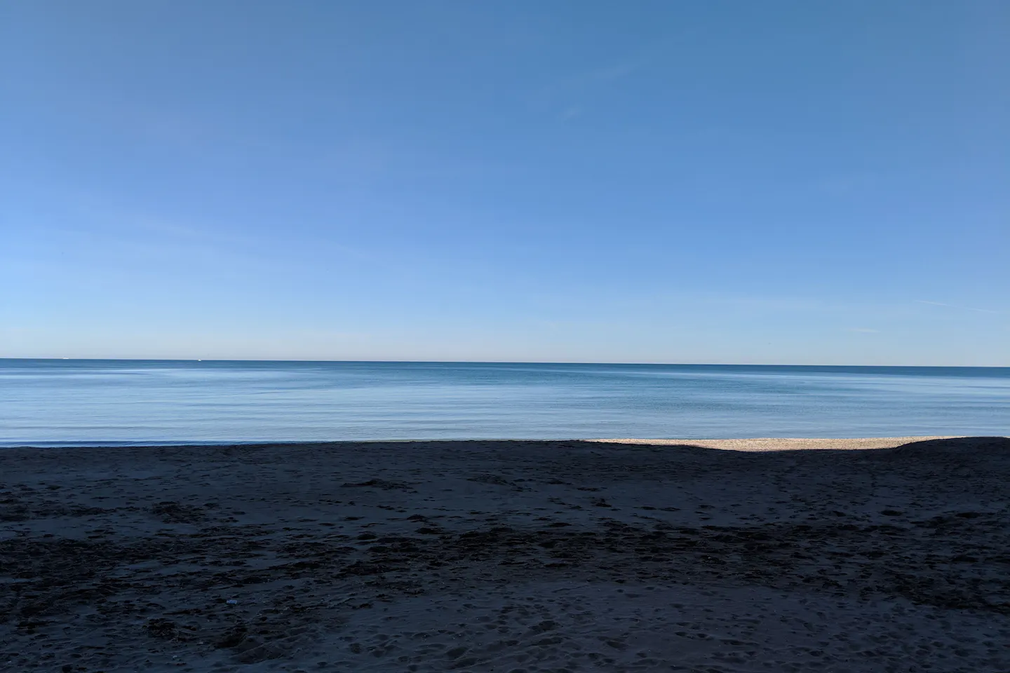 Calm sea and empty sand on a Spanish beach at sunrise